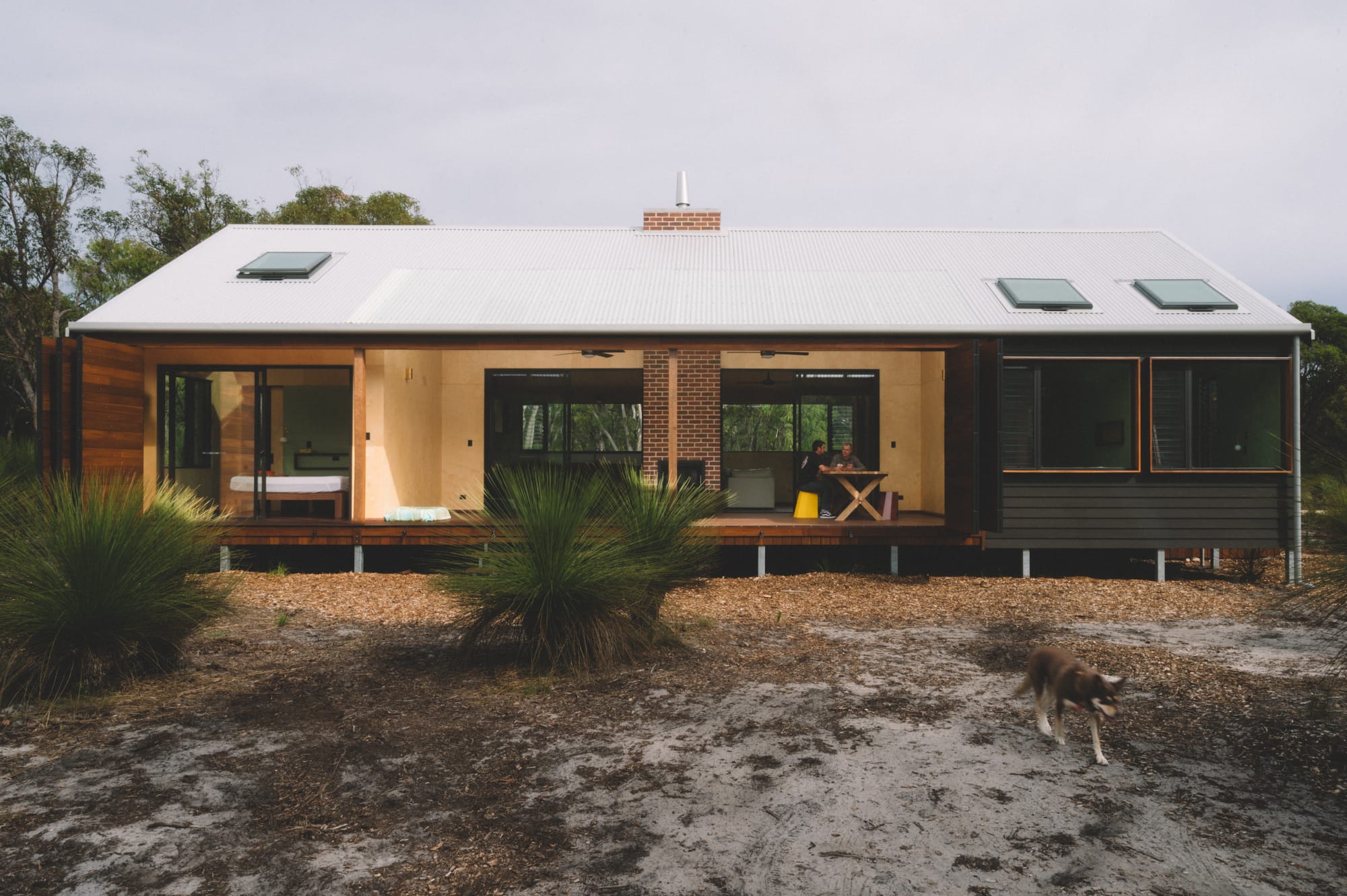 Nullaki House by Bare Architects. Minimalistic house on stilts with Japanese aesthetic and bifold wooden door facade.