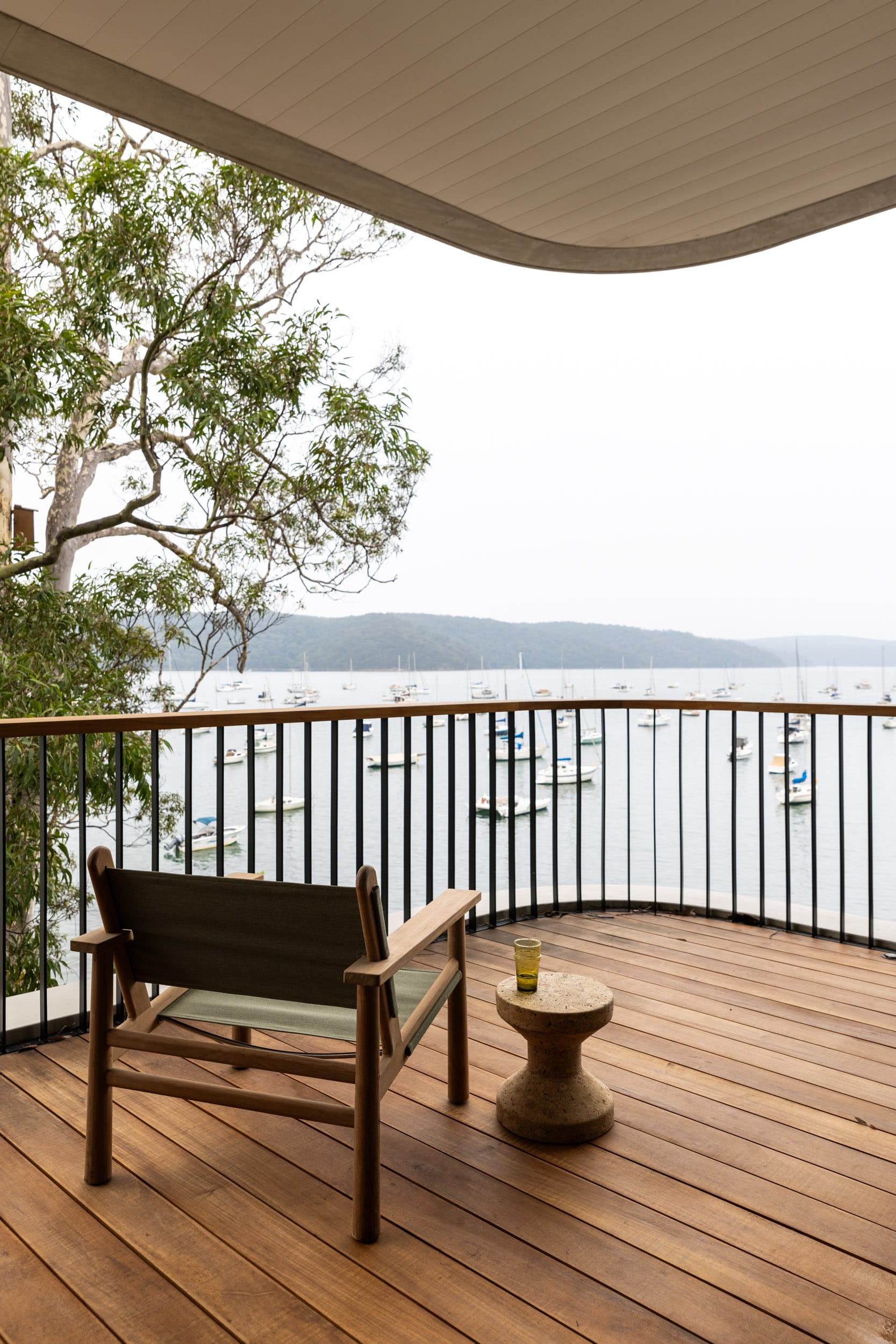 Ripple House by Marker Architecture. Wood panel balcony with view on harbor and mountains.