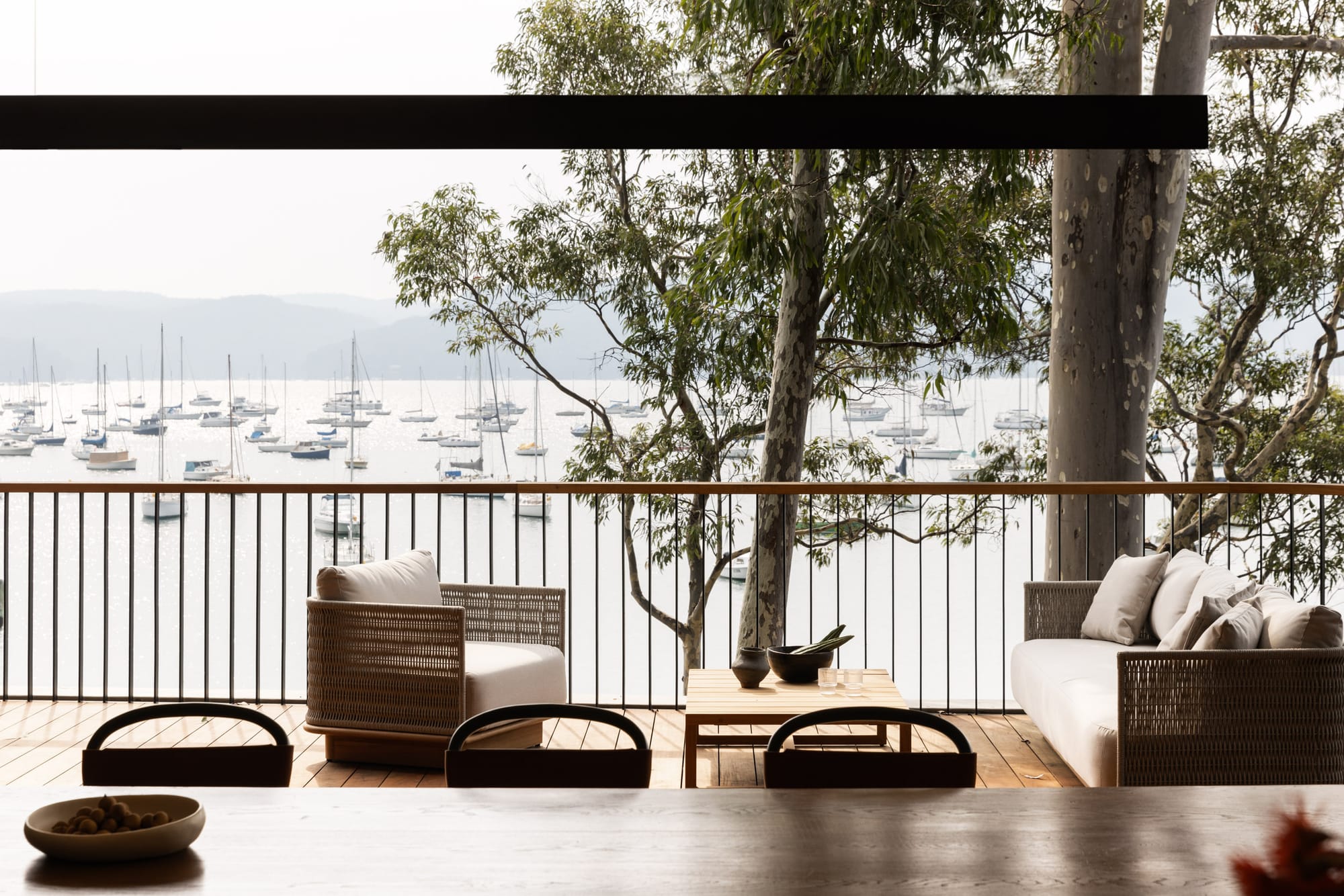 Ripple House by Marker Architecture. Wooden balcony with view on harbor, trees and mountains.