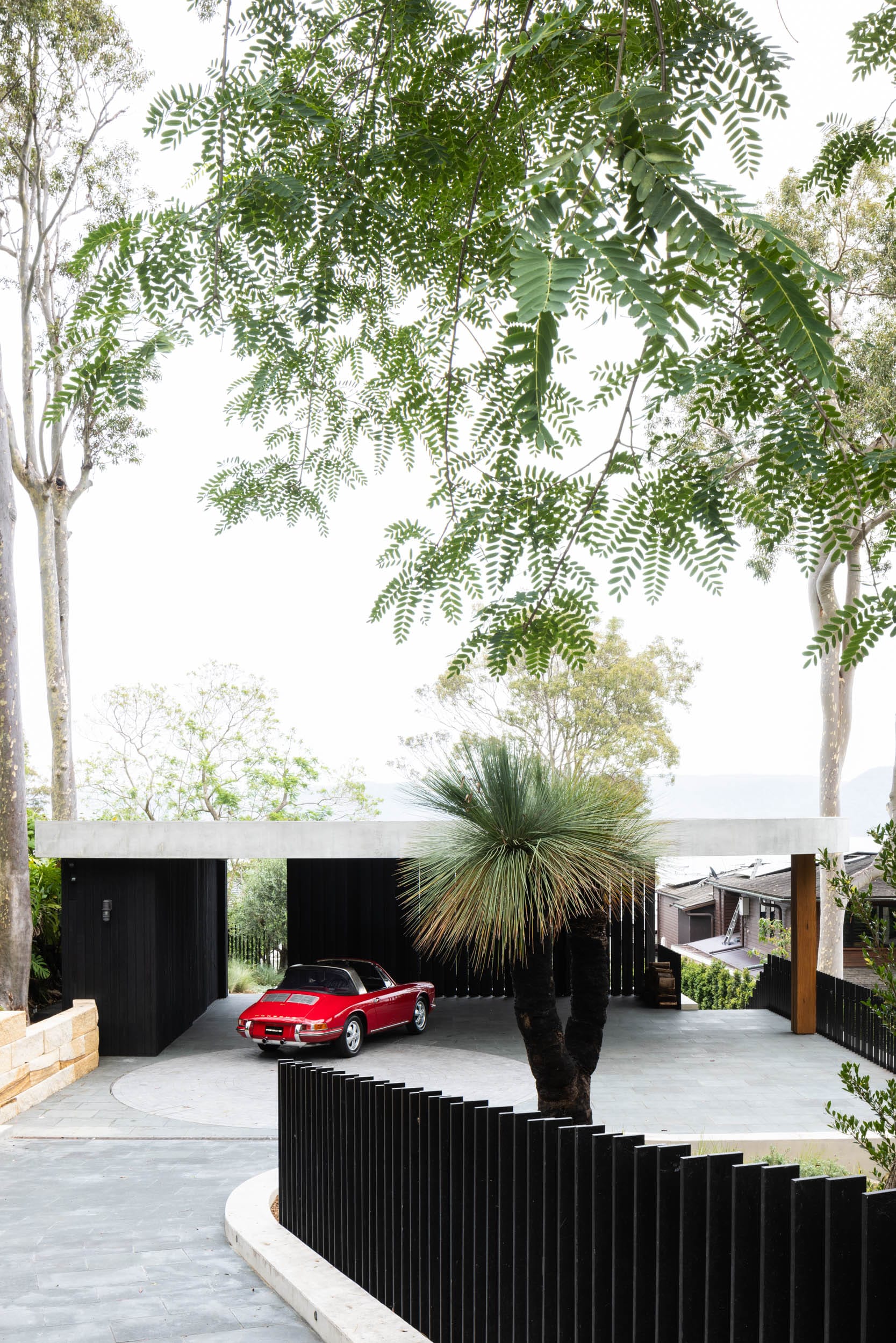 Ripple House by Marker Architecture. Driveway to canopy with red Porsche.