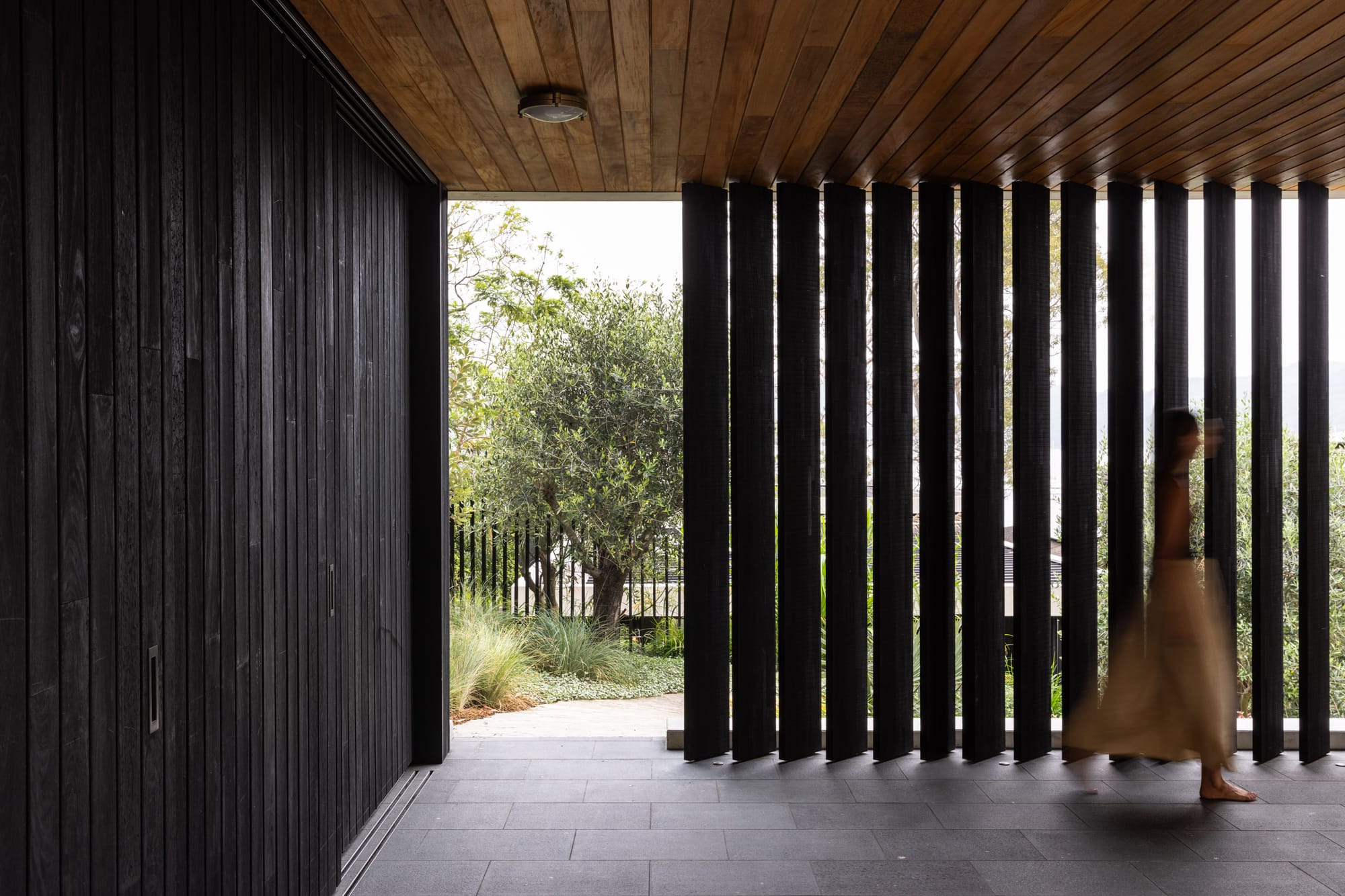 Ripple House by Marker Architecture. Canopy with view on black stained wood panels and trees. 