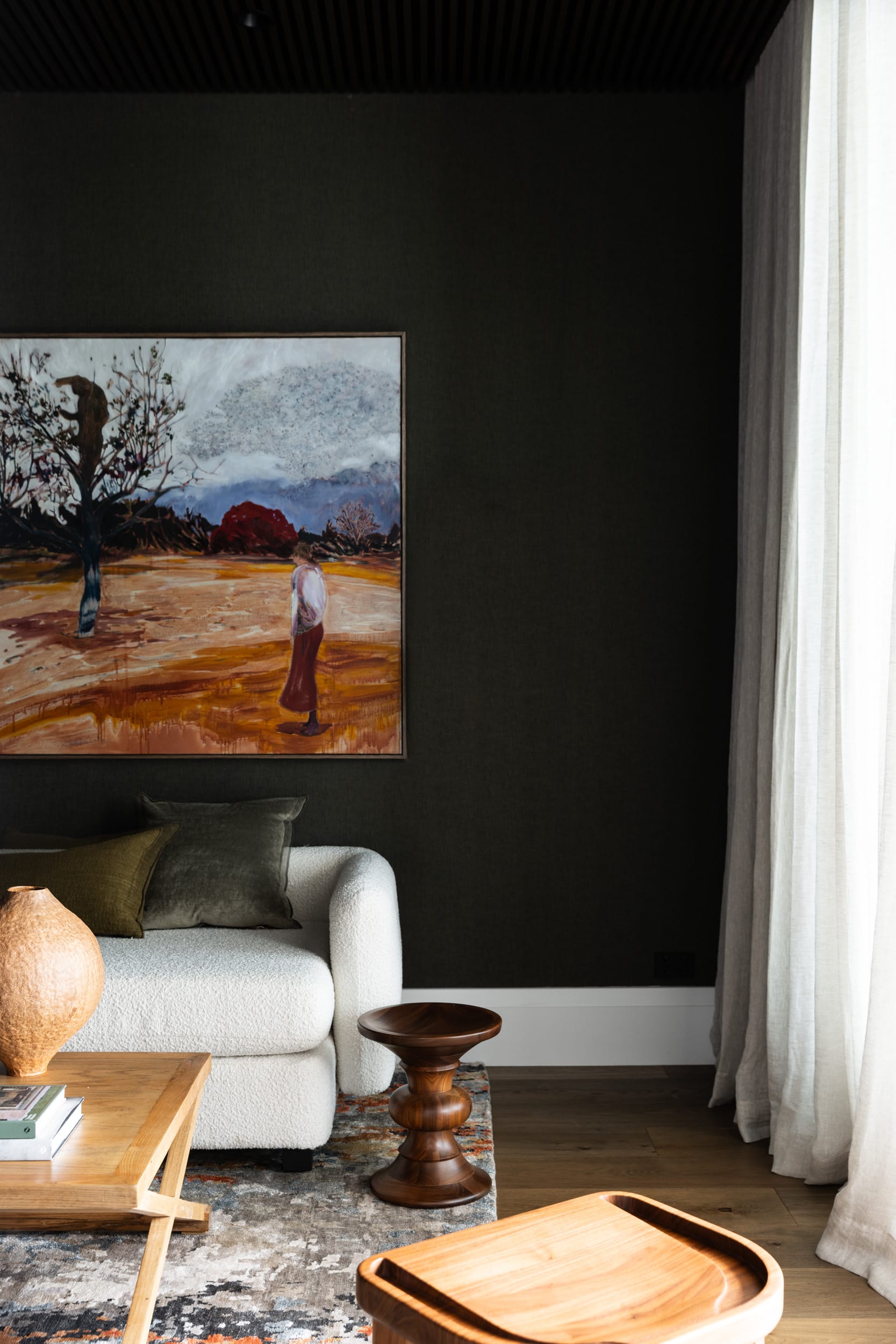 Ripple House by Marker Architecture. Detail shot of living room with white pouf sofa and hanging art.