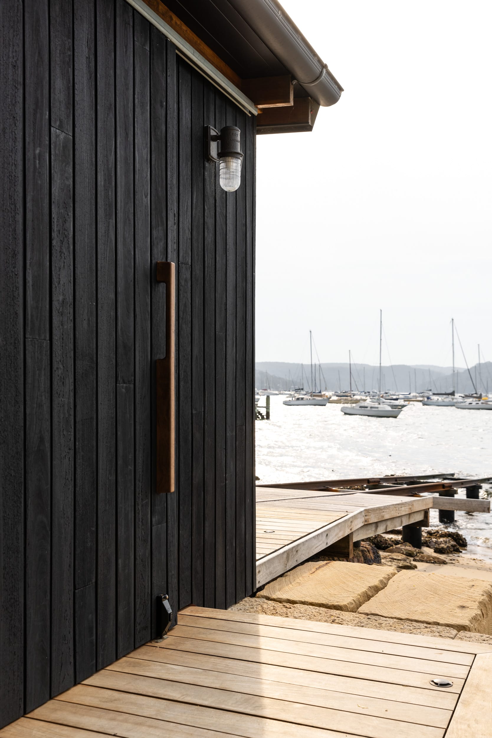 Ripple House by Marker Architecture. Black stained wood panel facade with view on harbor.