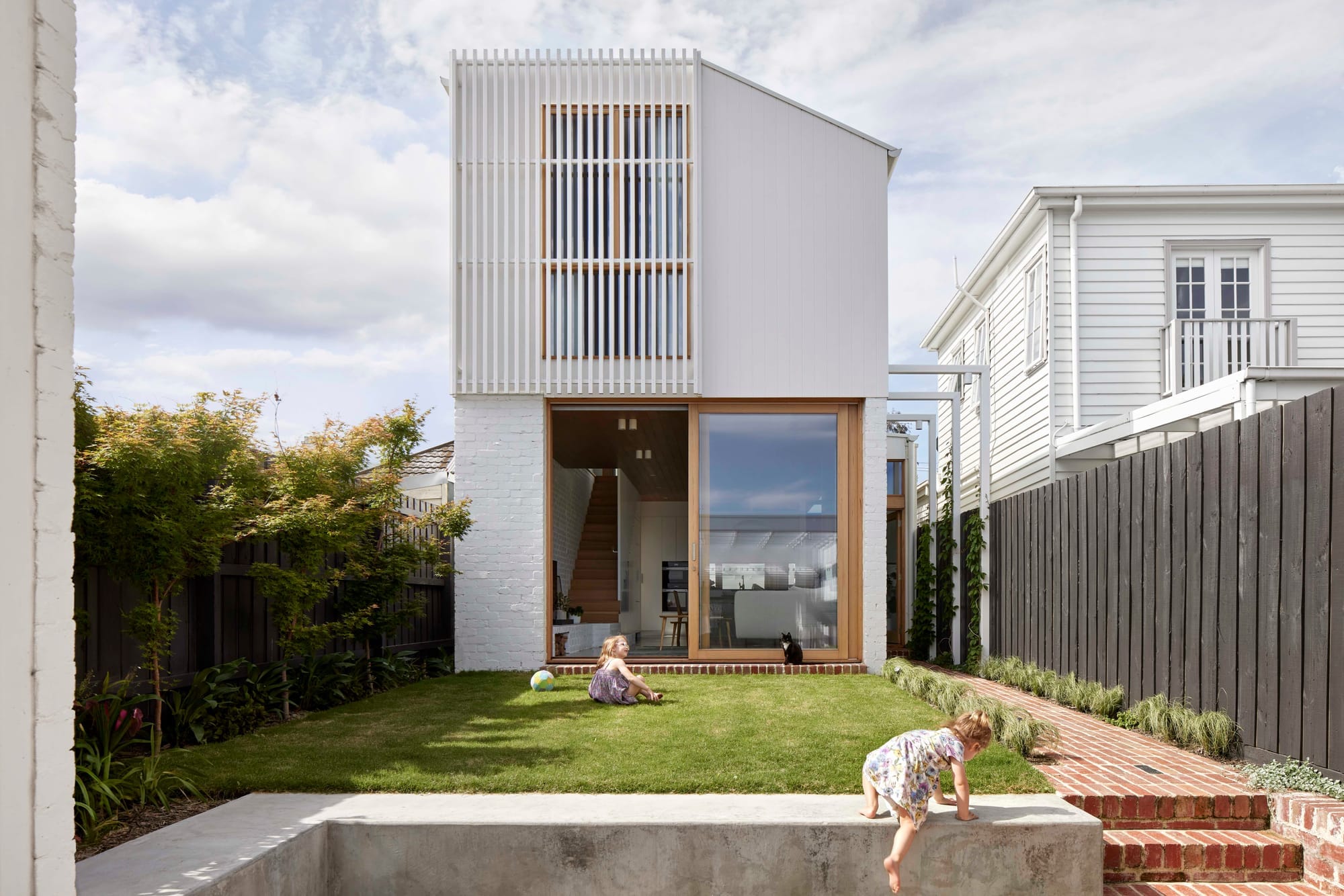 An exterior shot of Rosie by Eckersley Architects showing the rear elevation of the renovation project and two kids playing in the backyard