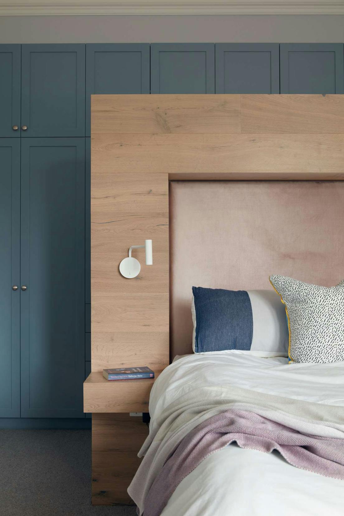 The Unbricked House by Merrylees Architecture. Bedroom featuring wooden bed and petrol, build in cabinet.