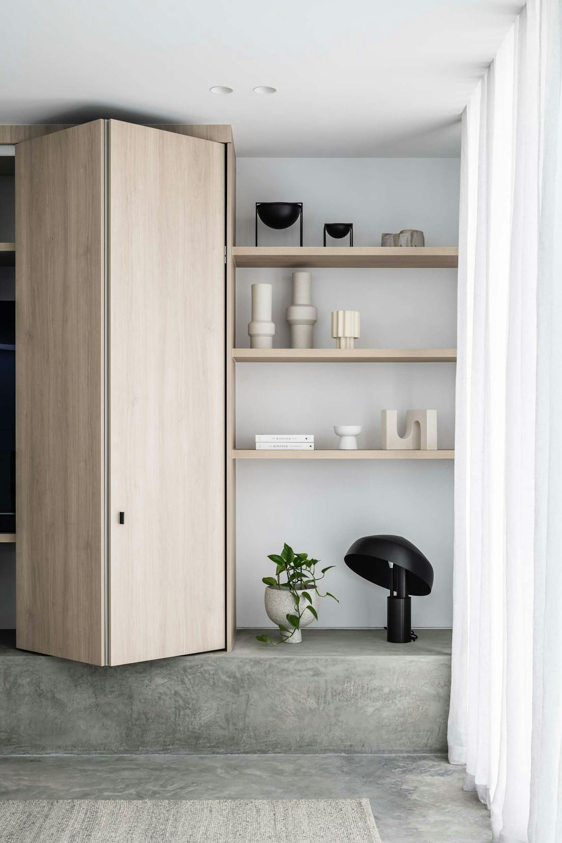 Elsterwick House by Merrylees Architects. Fitted wooden cabinet and shelf on cast concrete elevation. 