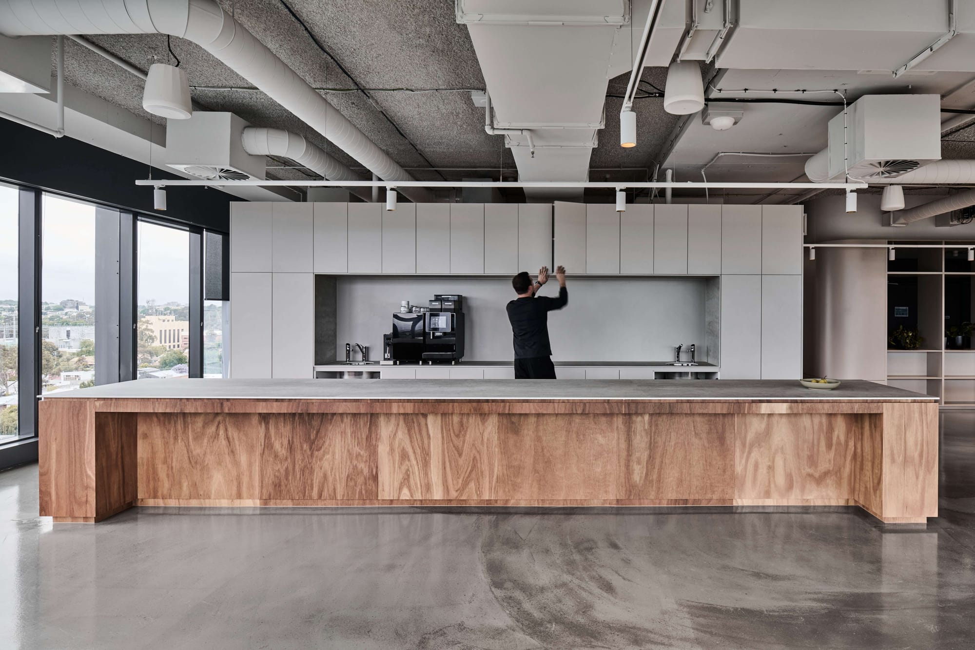 Icon HQ by FIGR. Office kitchen featuring varnished plywood kitchen counter and white fitted cabinets.