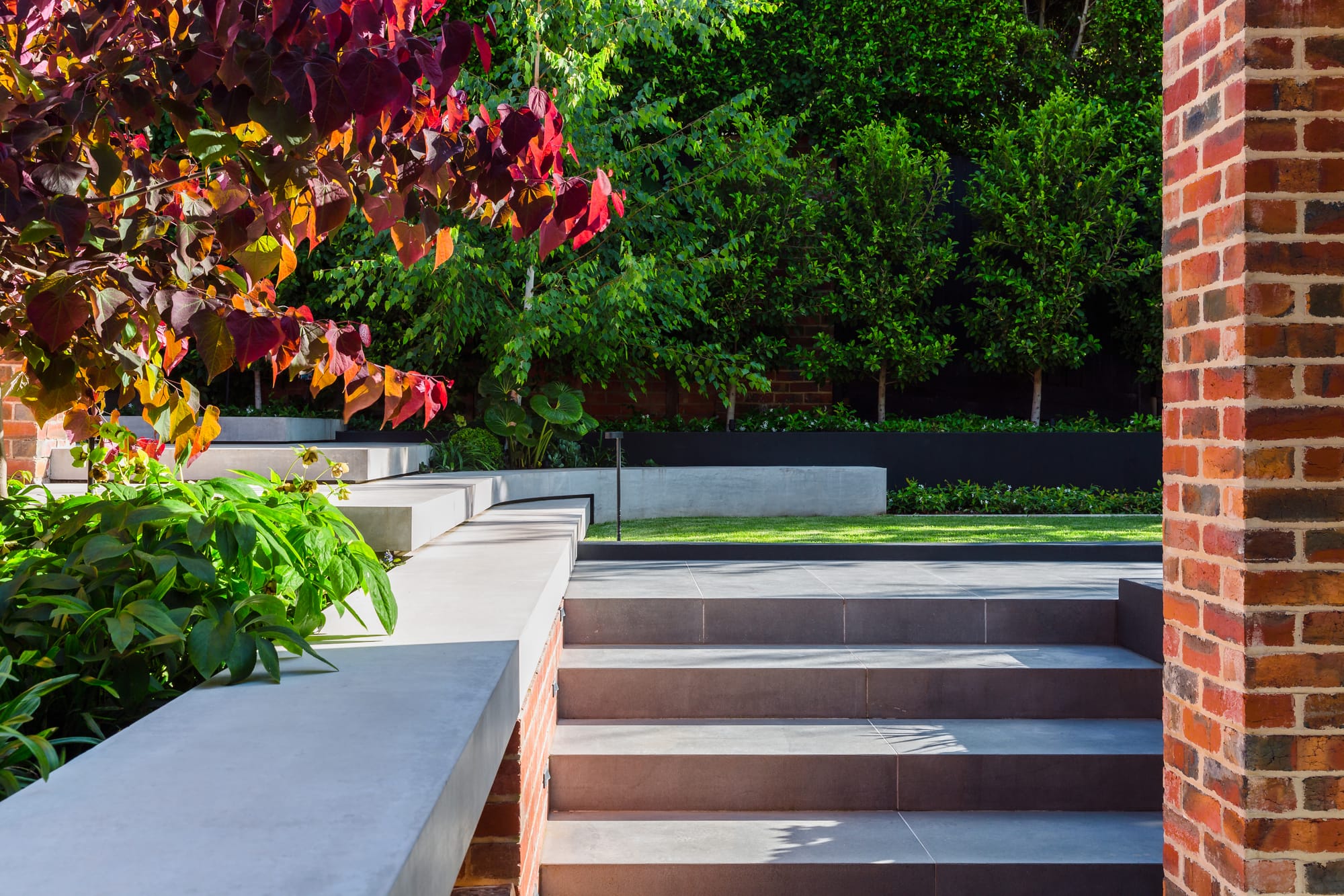 View to layered hardscape staircase and green garden.