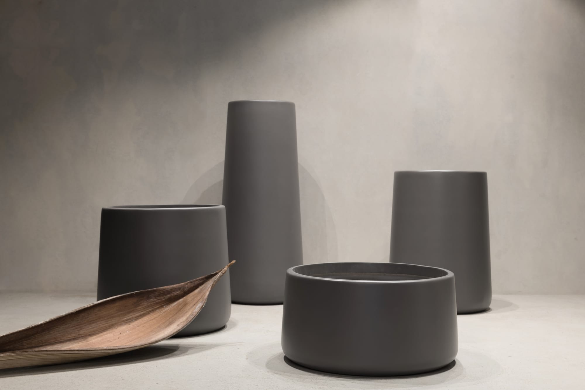 Outdoor Collection by Hibernate. Four handcrafted, lightweight, dark grey, high-quality marine-grade fiberglass plant pot.