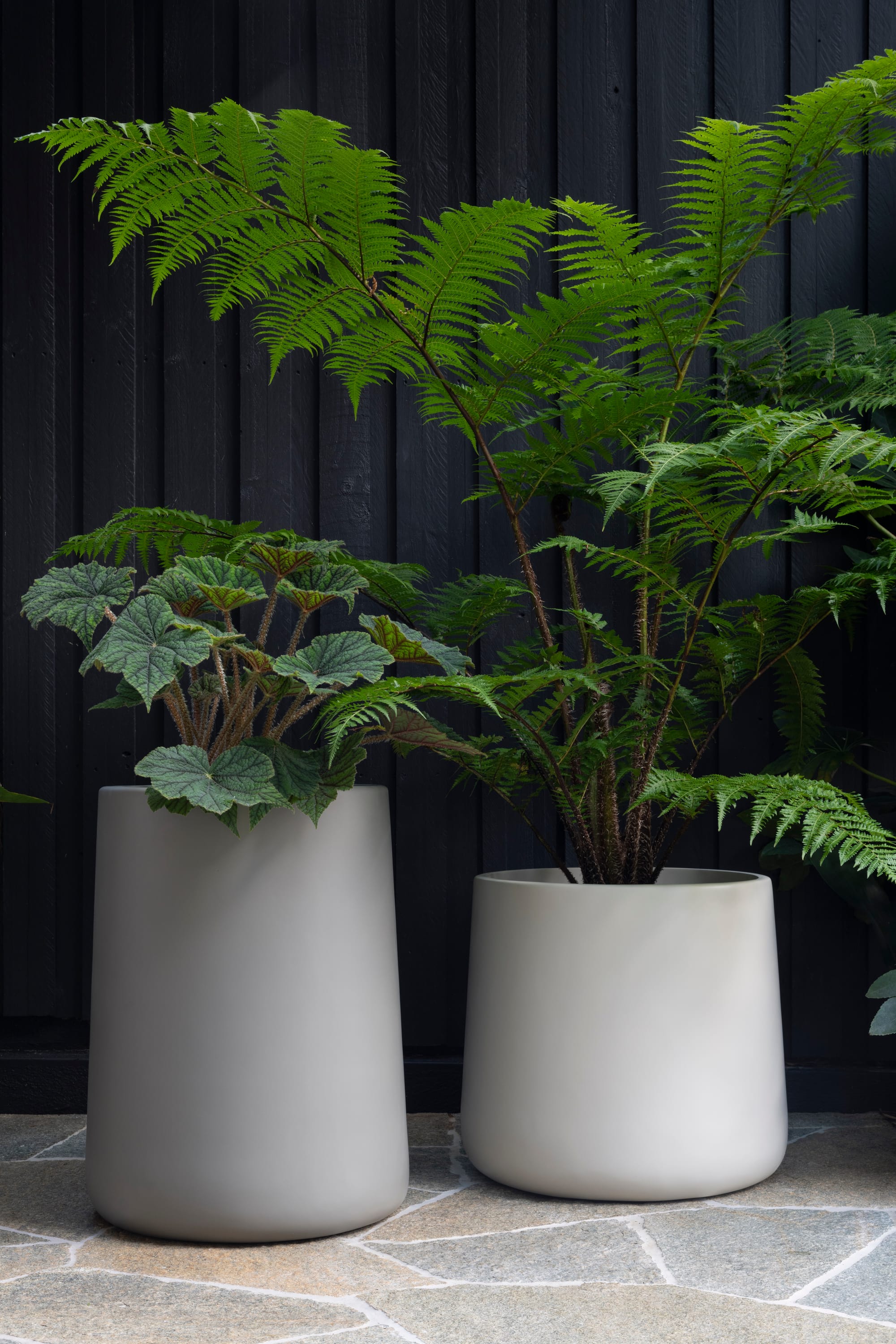 Outdoor Collection by Hibernate. Handcrafted, lightweight, light grey, high-quality marine-grade fiberglass plant pots featuring plants.