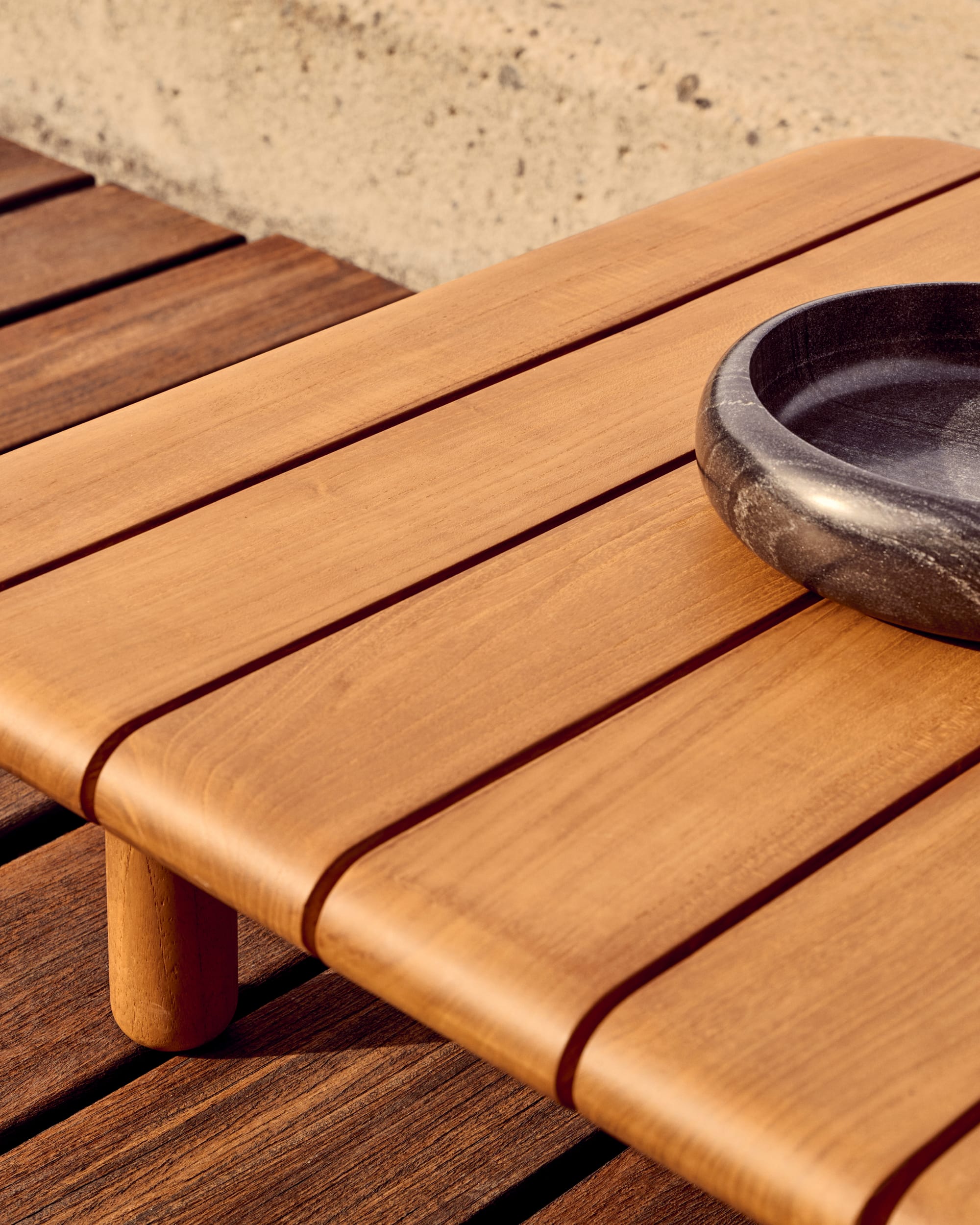 Turquetta by Kave Home. Curved teak wood outdoor coffee table on Mediterranean terrace.