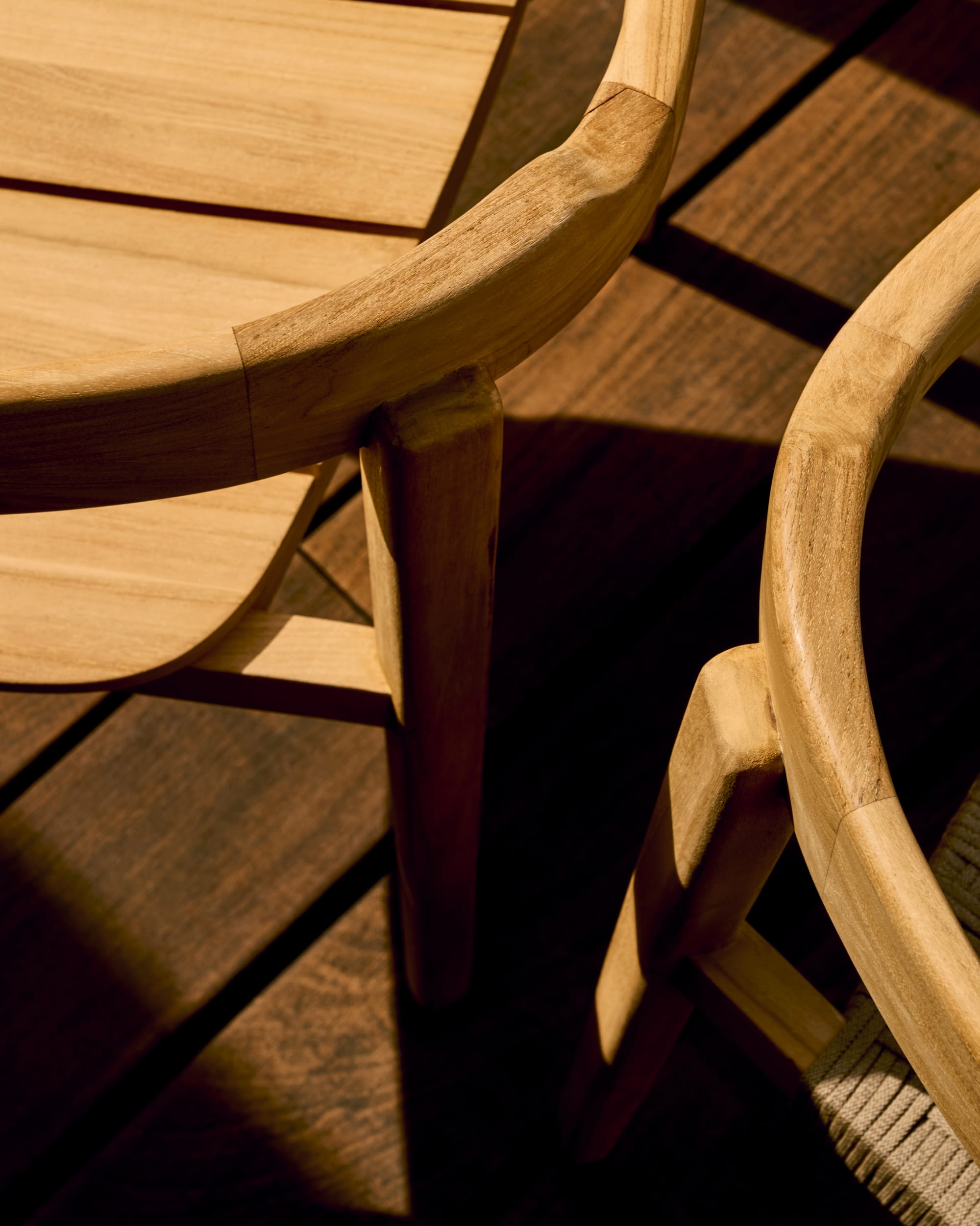 Icaro by Kave Home. Modern teak wood outdoor chair detail on Mediterranean terrace.