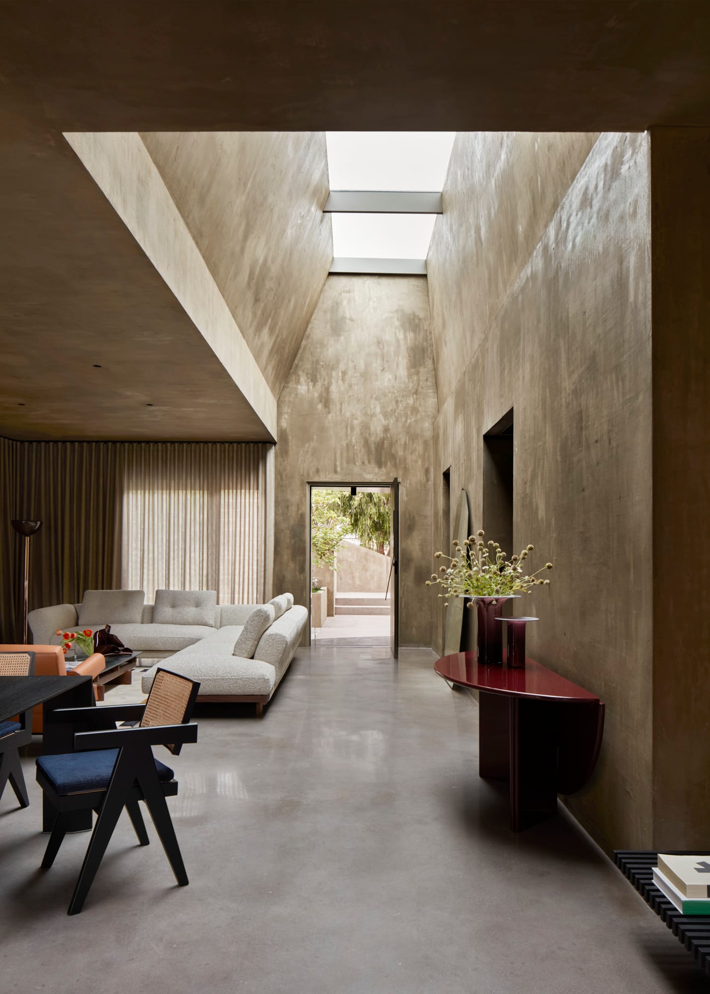 Proclamation House by State of Kin. Modern contemporary interior featuring white Sengu sofa, Capitol complex dining chairs peeked roof and skylight.