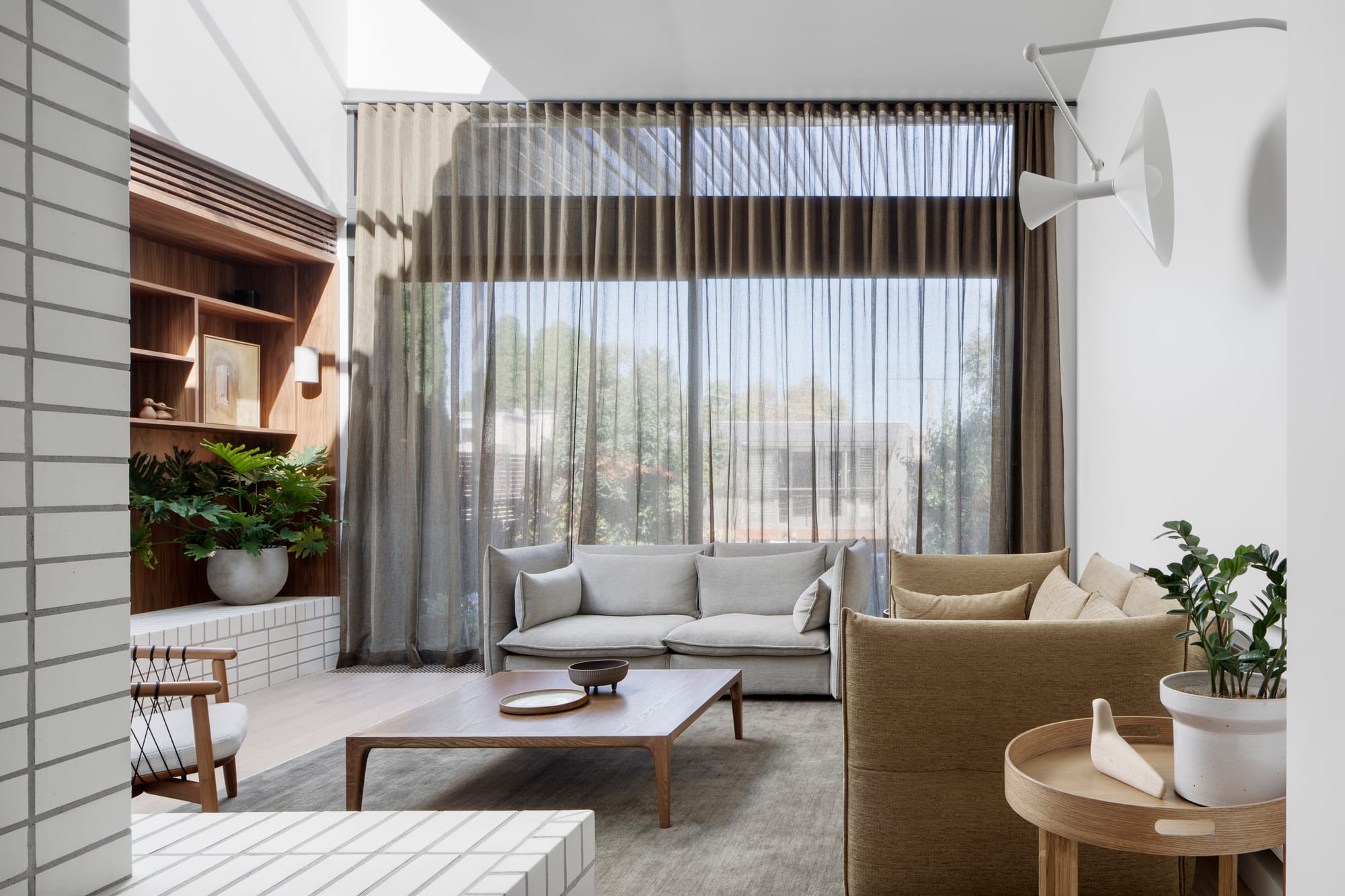 South Terrace Residence by Chan Architecture. View to modern minimalistic living room featuring skylight, white brick wall, floor to ceiling window. 