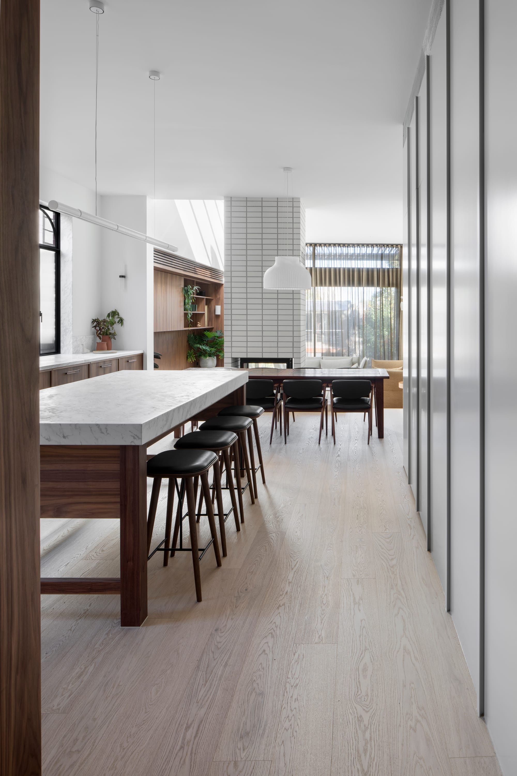 South Terrace Residence by Chan Architecture. Narrow view to kitchen area and separated living space featuring light and welcoming atmosphere.