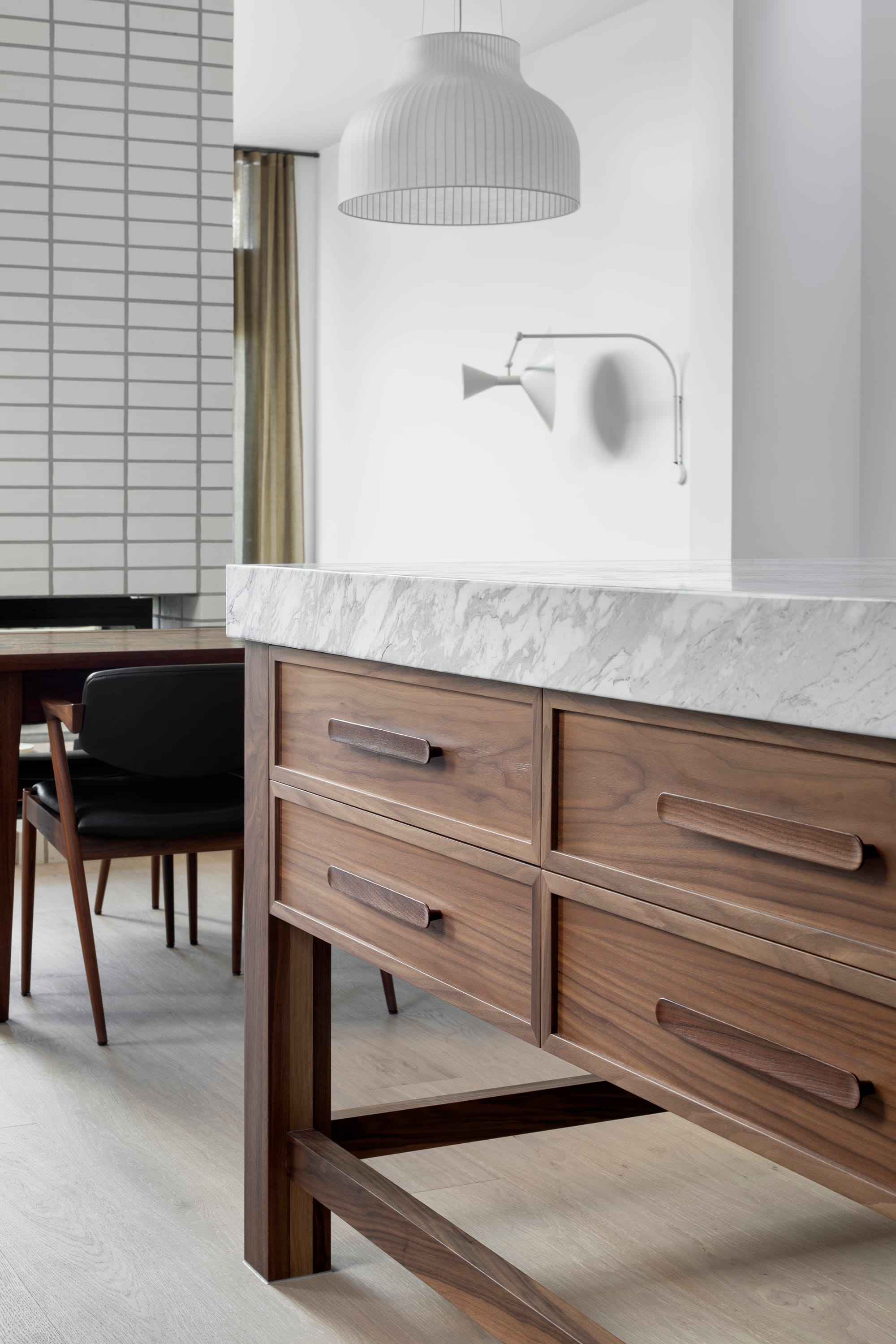 South Terrace Residence by Chan Architecture. Kitchen island detail featuring walnut wood and white marble worktop.