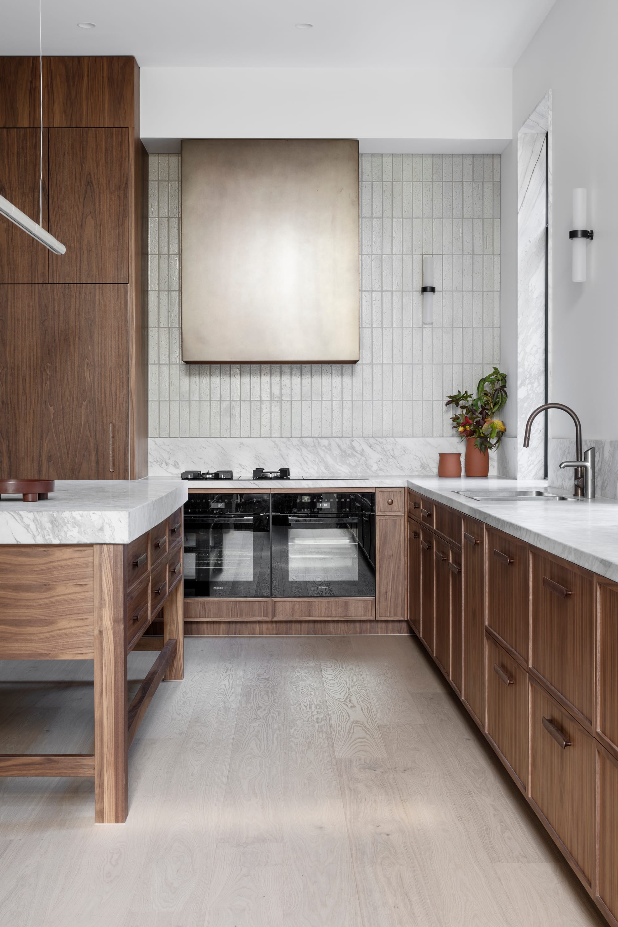 South Terrace Residence by Chan Architecture. Kitchen area with dark walnut wood and white marble worktop.