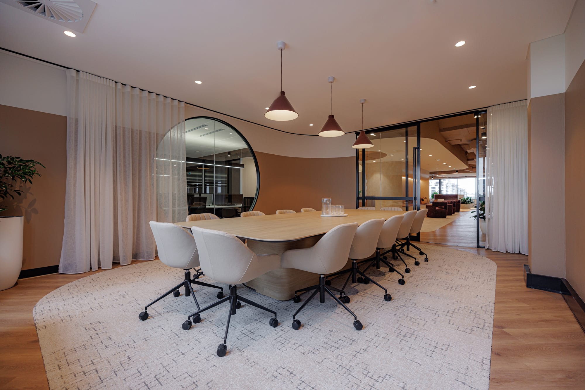 St Leonards Centuria Office Fit-Out by Alinea. View to office meeting room featuring wooden table and fabric office chairs.