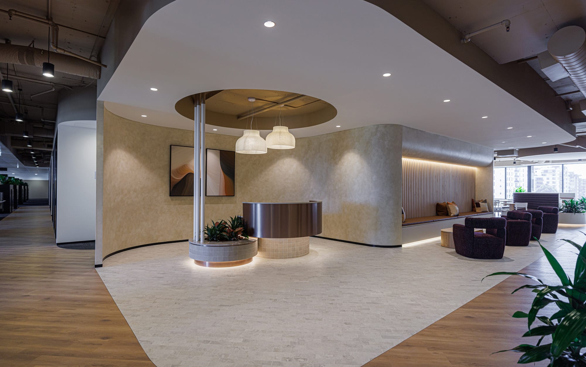 St Leonards Centuria Office Fit-Out by Alinea. View to customised, round reception desk and office lounge area featuring suspended ceiling.