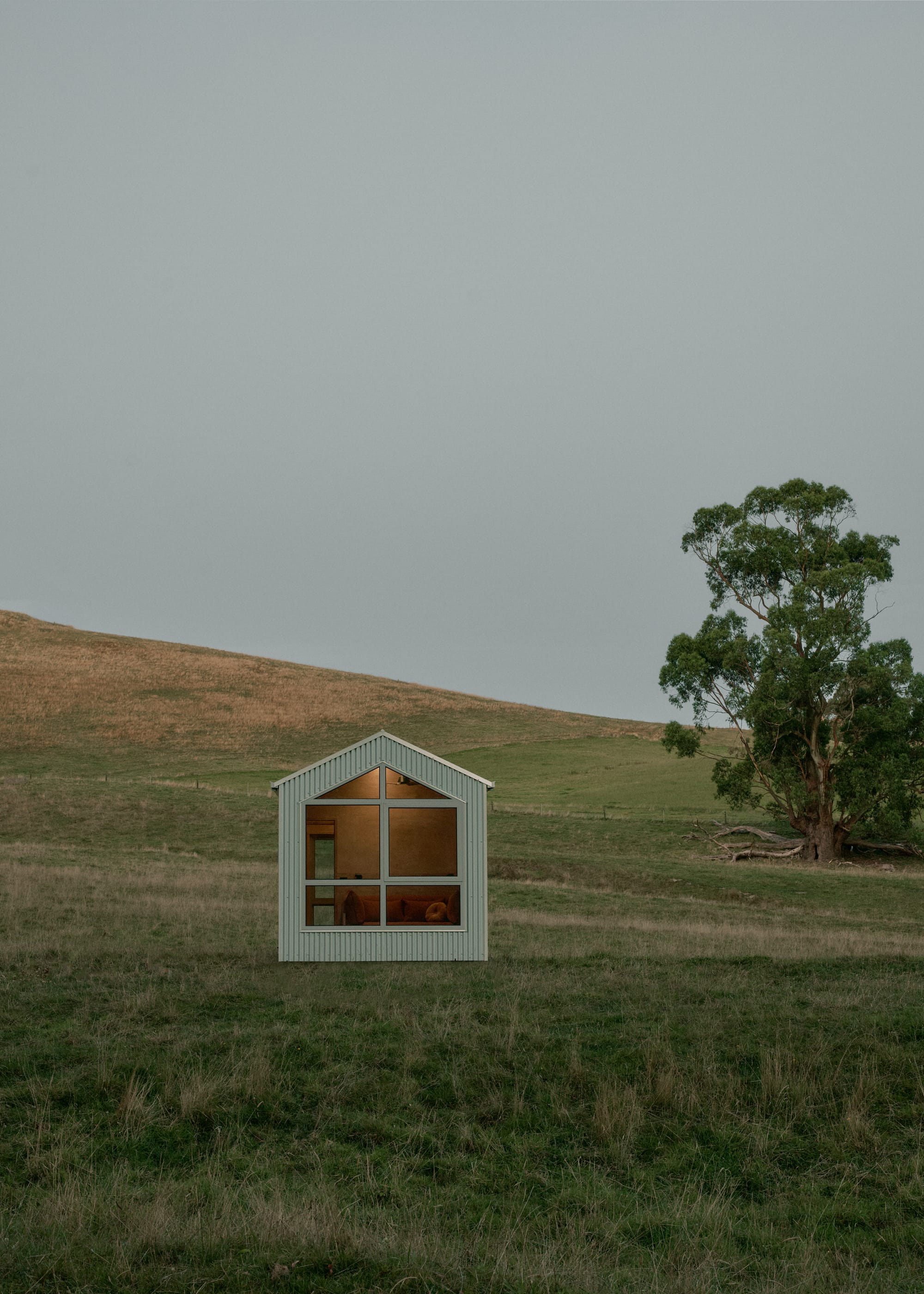 The Shearers Quarters by Base Cabin. White tiny house featuring warm and minimalistic interior on a meadow.