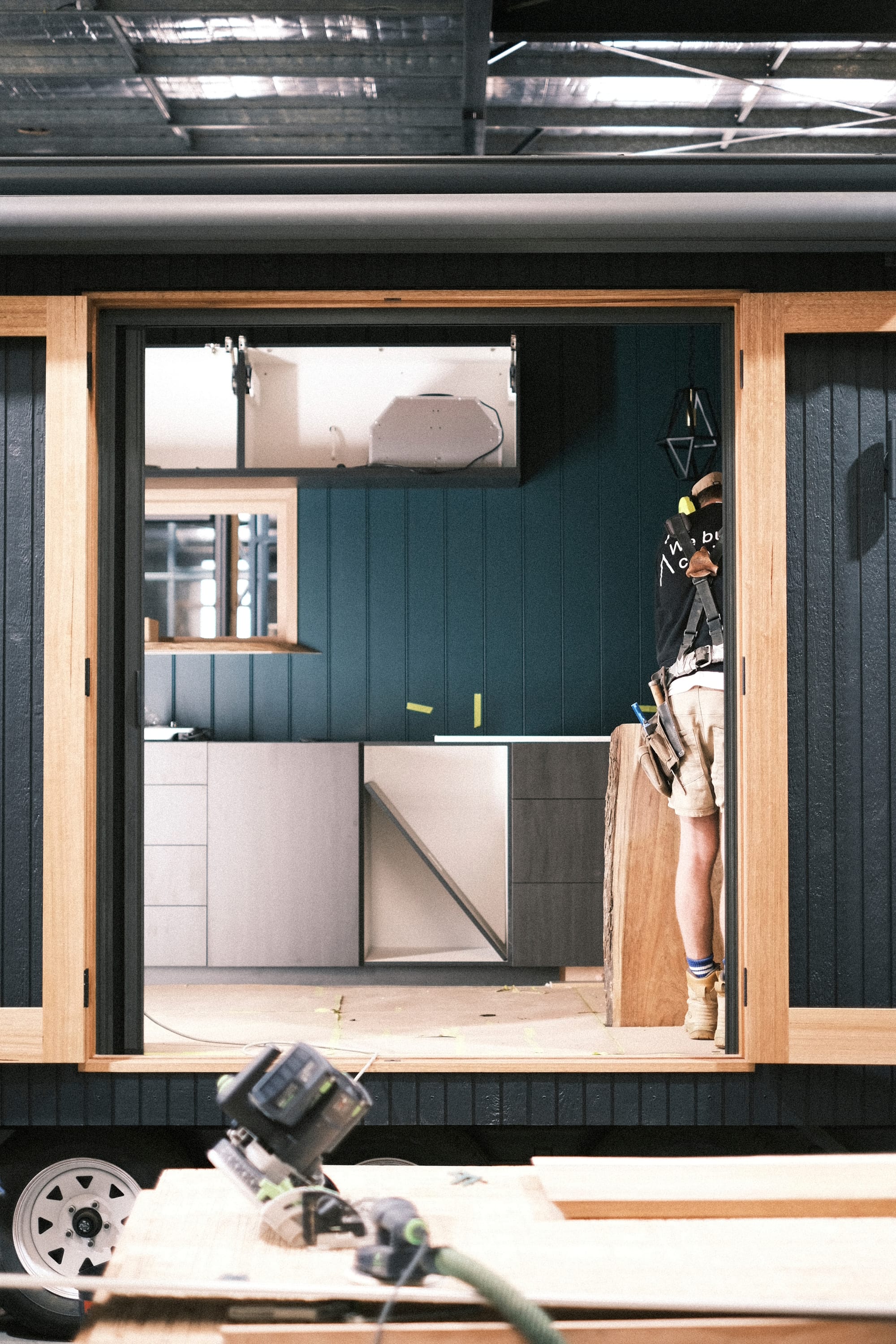 Workshop at Base Cabin. Workshop with view to tiny house construction featuring black wood panel facade and wooden door frame.