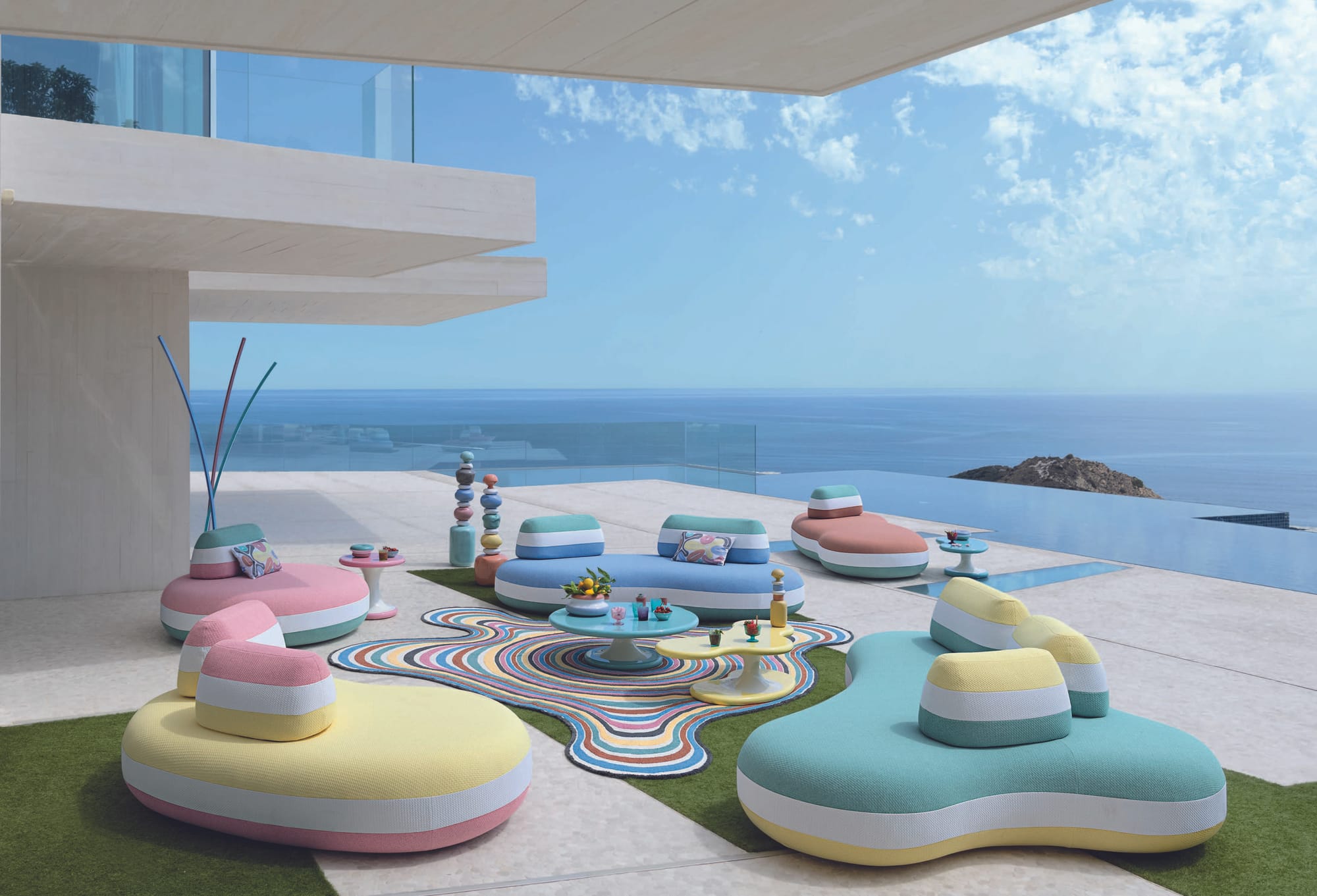 Outdoor Collection by Roche Bobois. Contemporary colorful roundly sculpted outdoor sofas and chairs next to infinity pool.