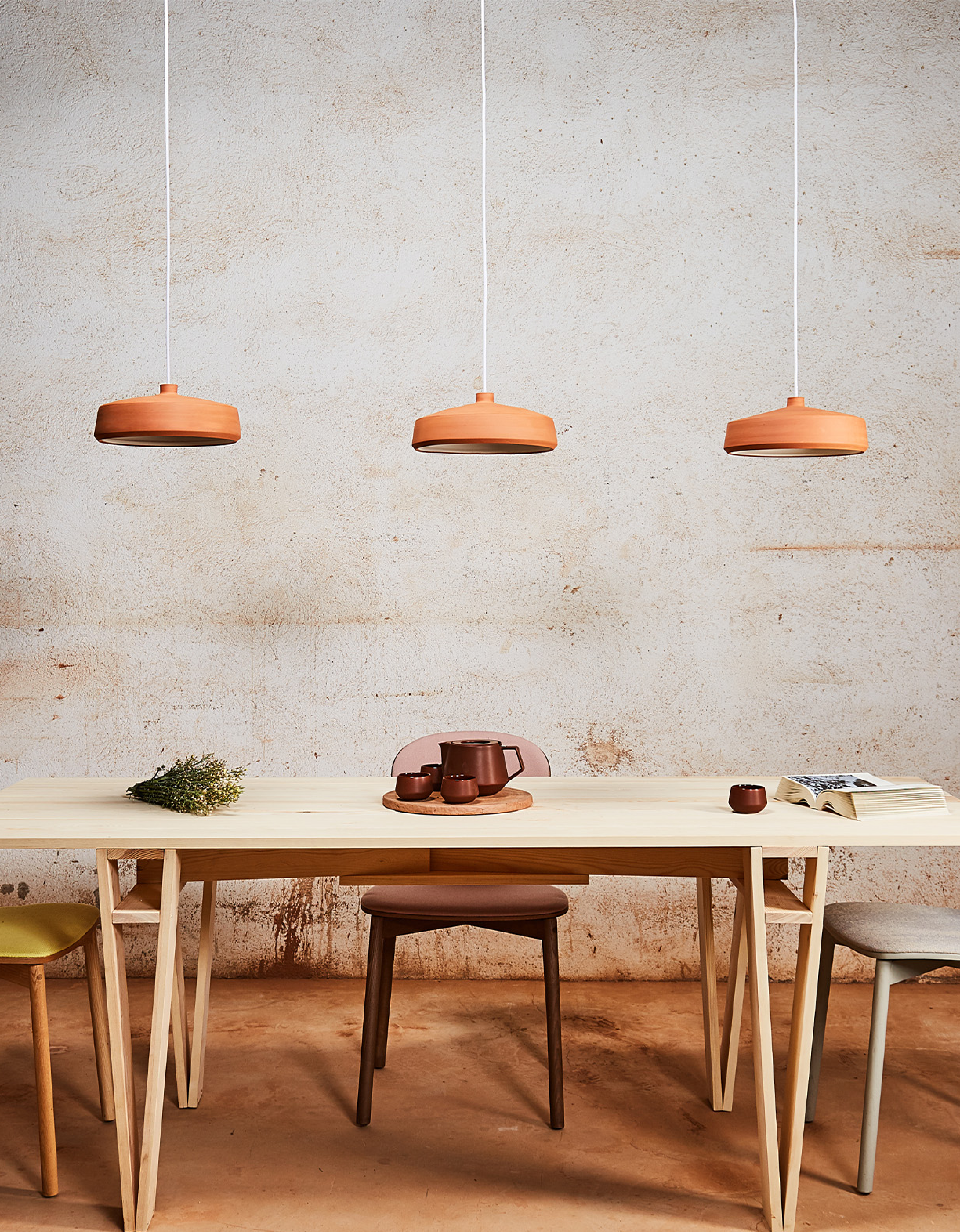 Flame Pendant Light by Klaylife with Lighterior. Dining area featuring cylinder shaped clay pendant lights, wooden table and modern chairs.