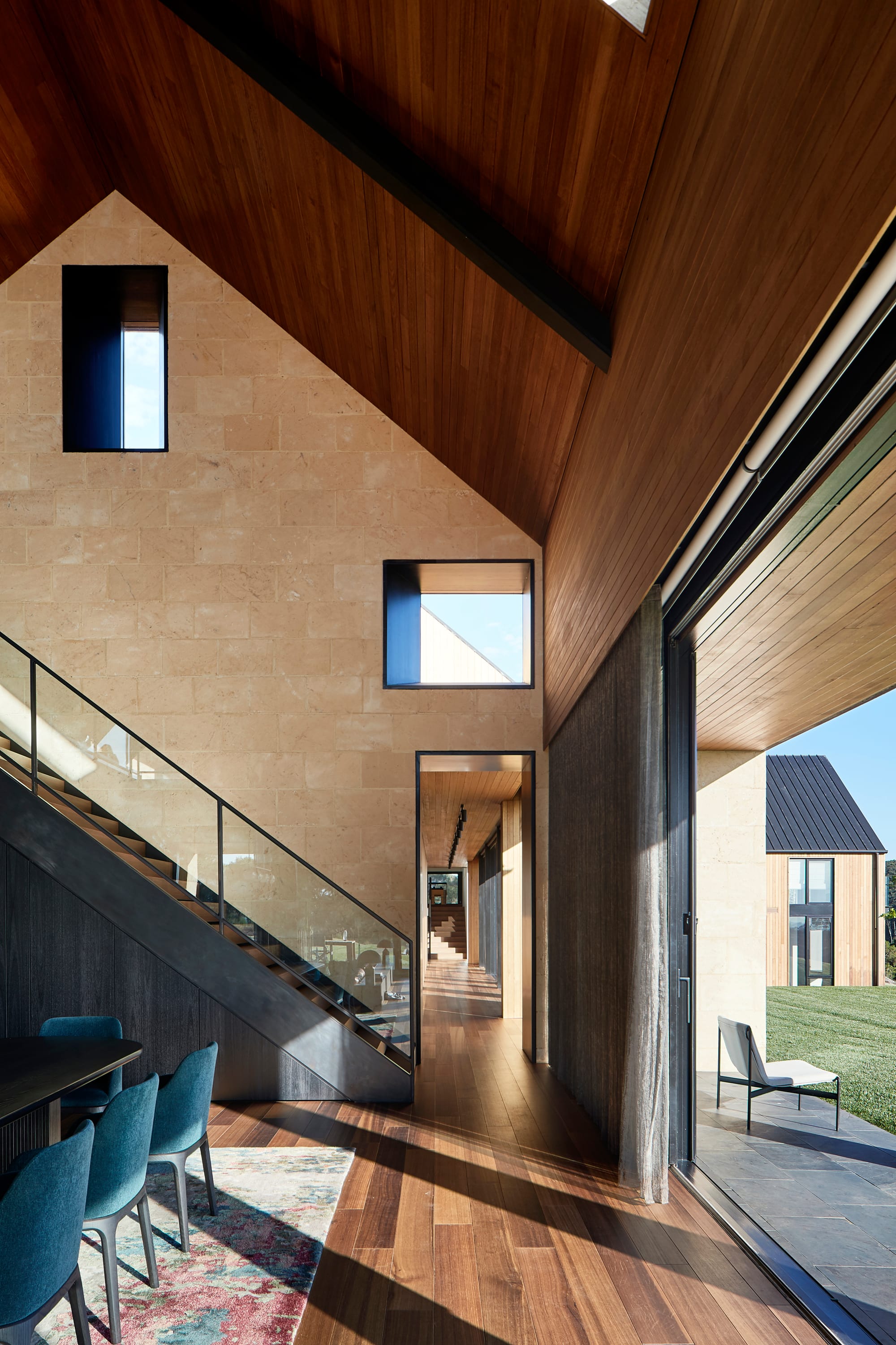 Flinders Residence by Abe McCarthy. Modern residence interior featuring gable roof, view to dining, hallway and garden.