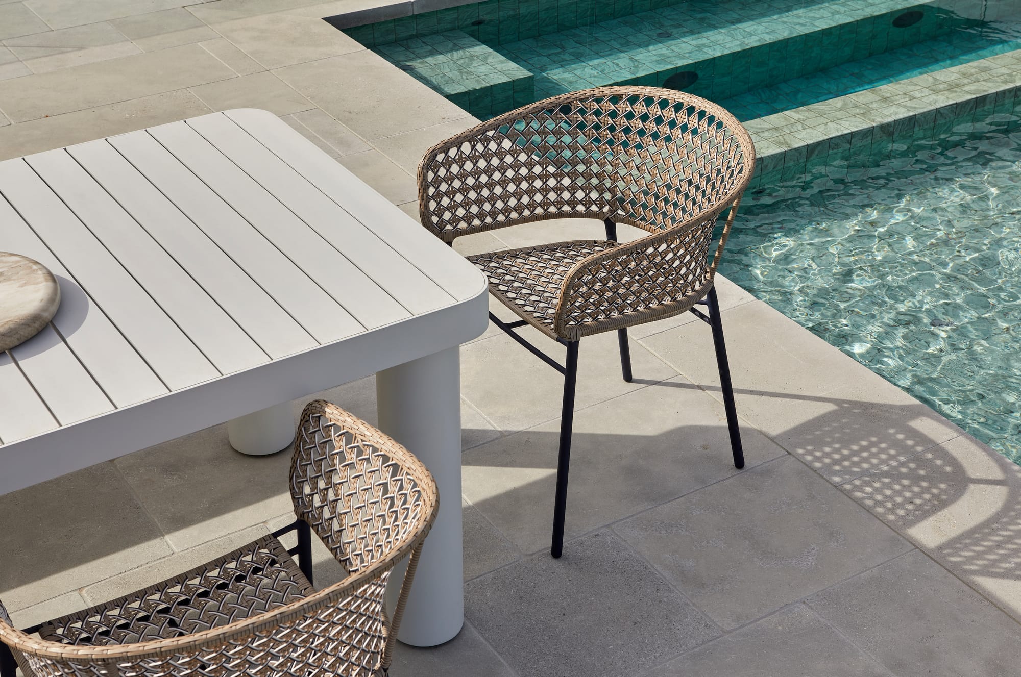 Frankie Outdoor Chairs & Table by GlobeWest. Modern outdoor dining set featuring woven chairs and white table at pool.