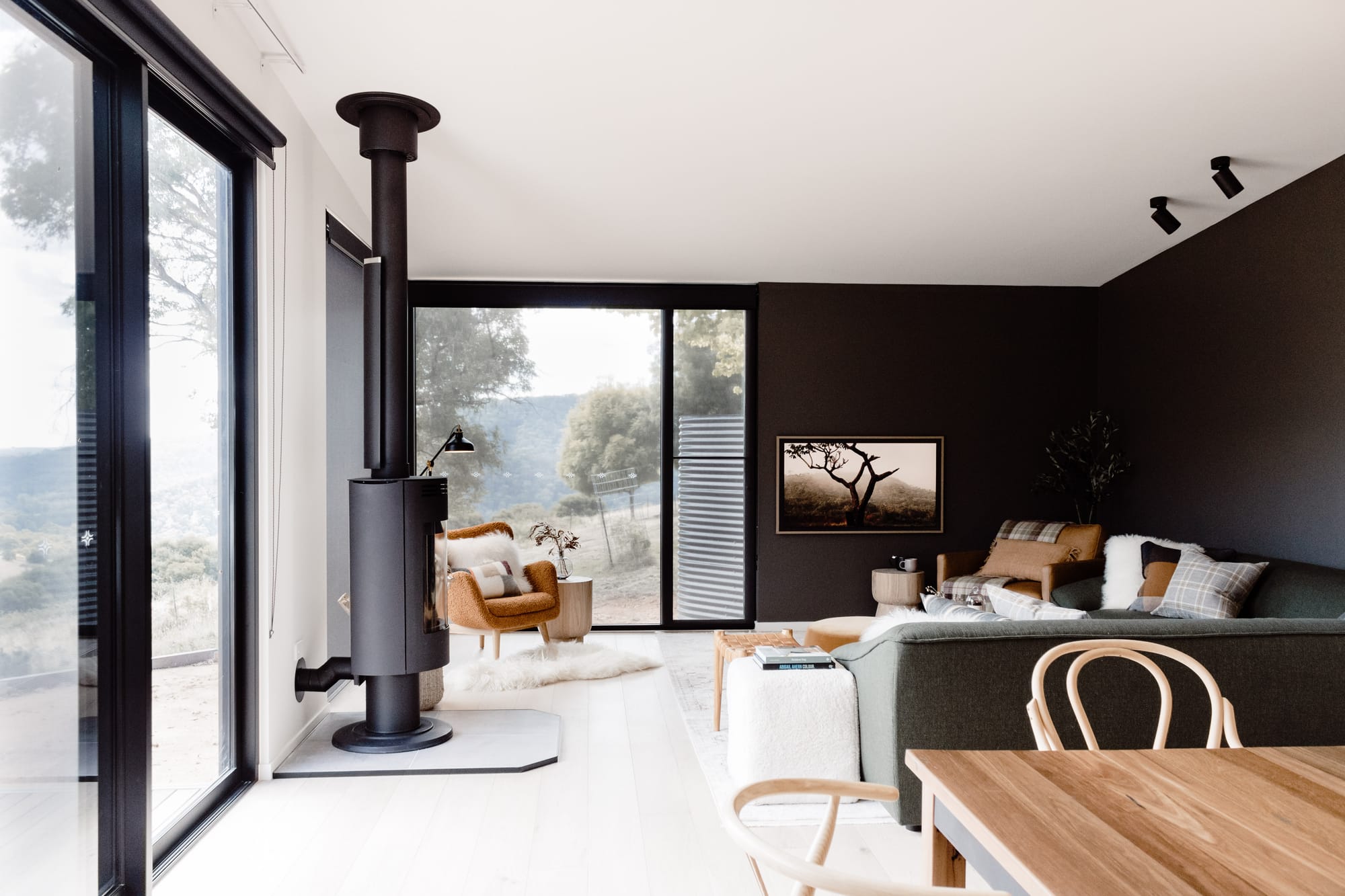 Roam Escape by Roam Merrijing. Modern minimalistic light flooded living space featuring chimney, dining and sofa.