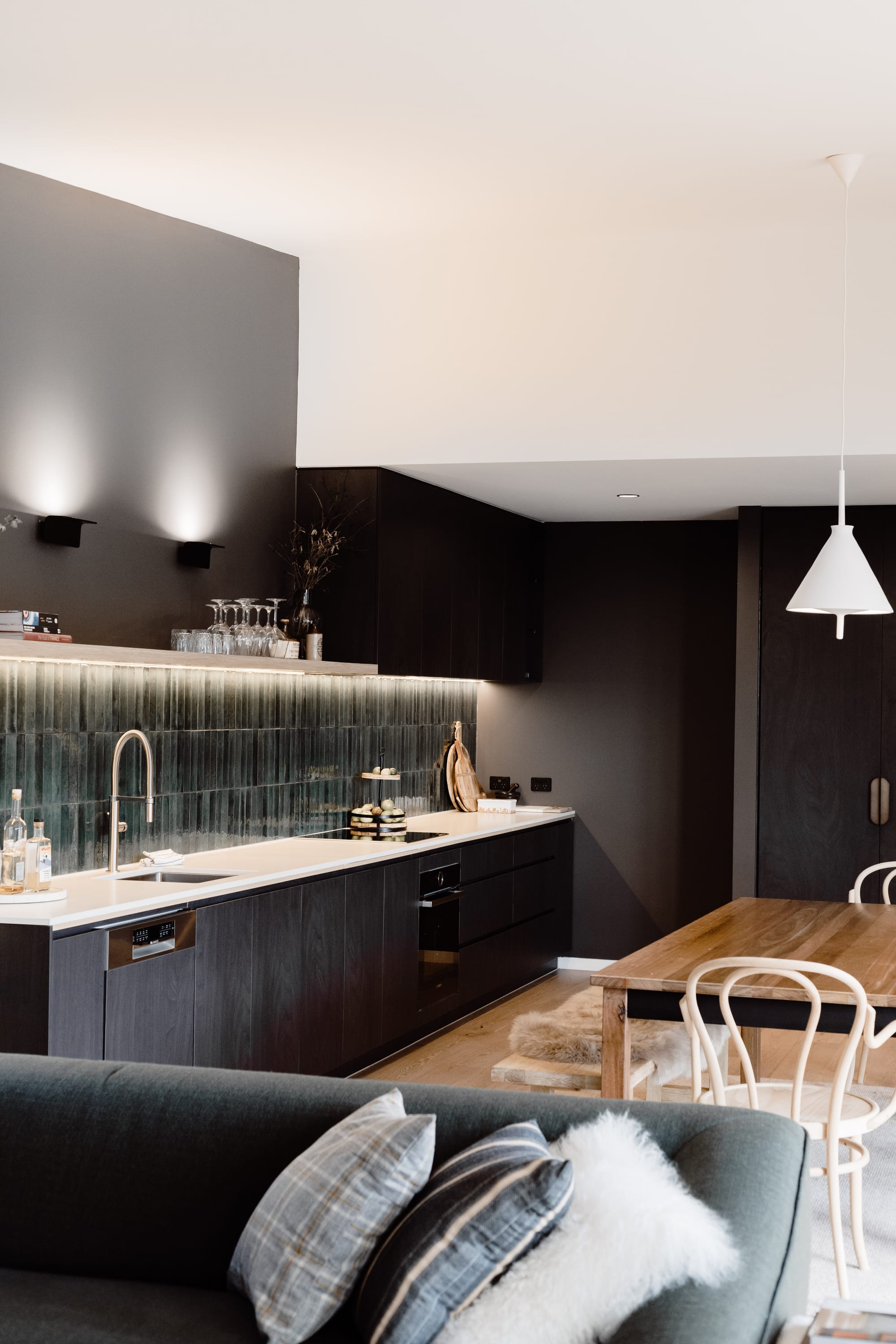 Roam Escape by Roam Merrijing. Modern living space featuring black stained wooden kitchen and ceramic tiles.