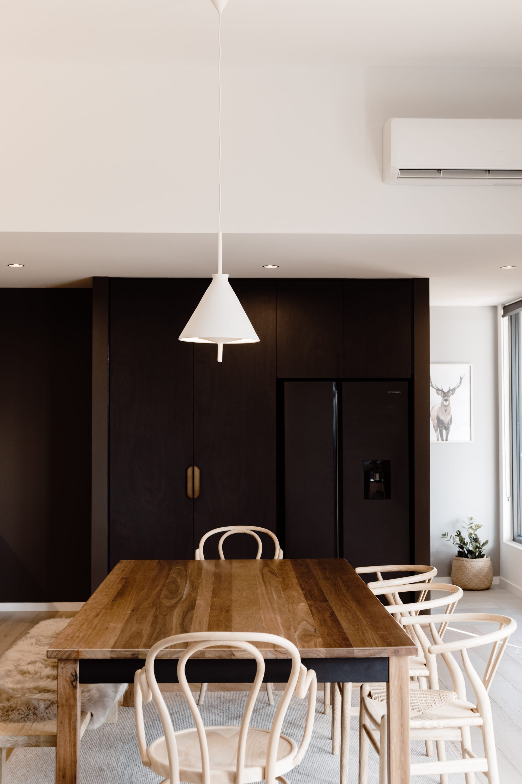 Roam Escape by Roam Merrijing. Dining space featuring Scandic chairs and fitted cabinet made from dark wood.