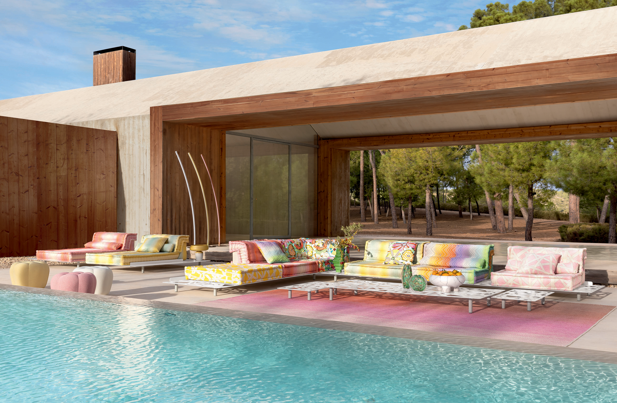 Outdoor Collection by Roche Bobois. Colorful modern outdoor sofa next to pool and modern house.