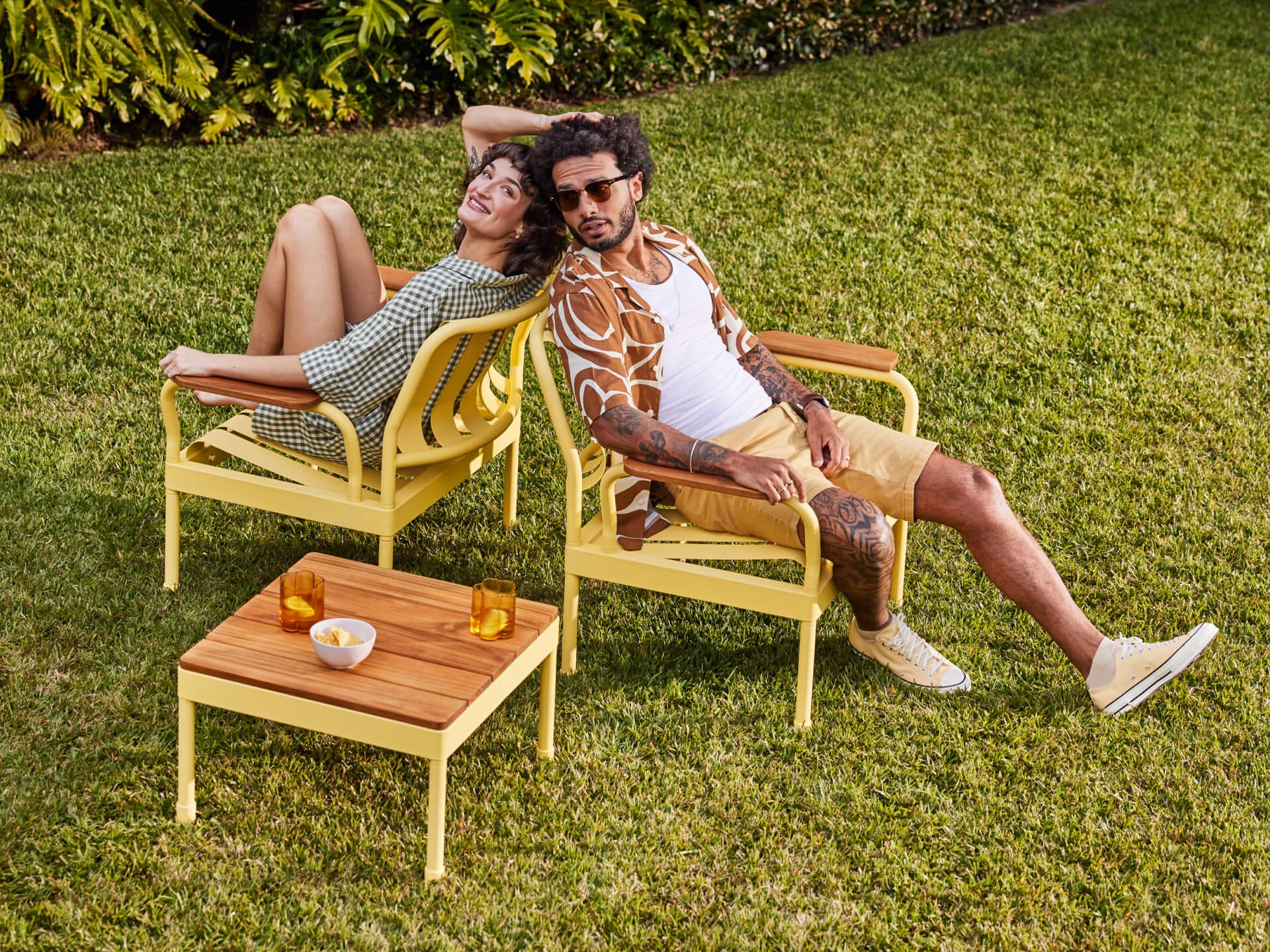 Torakina Outdoor by Koala Living. Models on lounge chairs with coffee table featuring modest design, local oak and soft yellow steel construction.