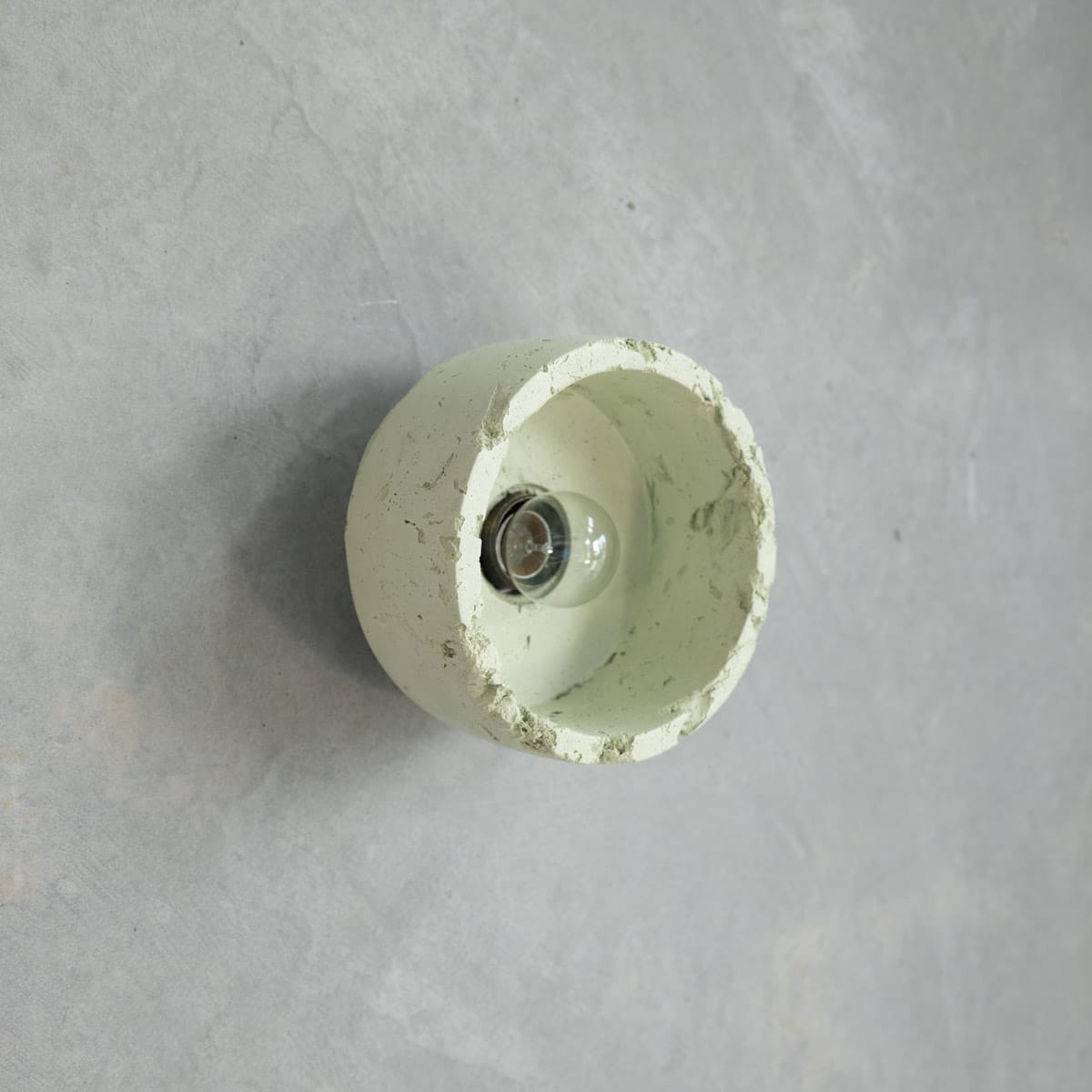 Dorea Wall Light in Moss. Image copyright of Crete Studio. Light sage green wall sconce concrete light fixture with raw texture. 