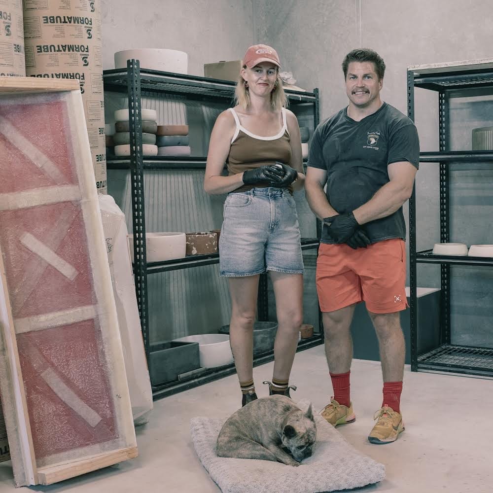 Crete Studio. Image copyright of Crete Studio. Man and woman standing in pottery studio with dog on floor in front of them. 