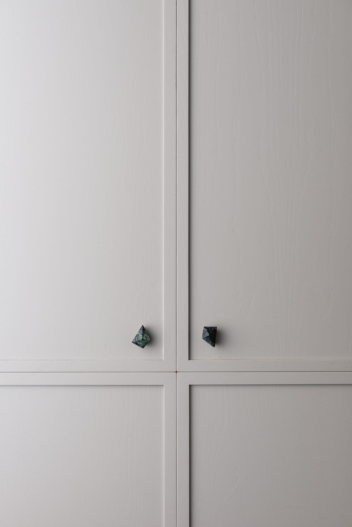 PRISM collection by Lo & Co. Showing the designer door ware on some grey cabinets in green marble