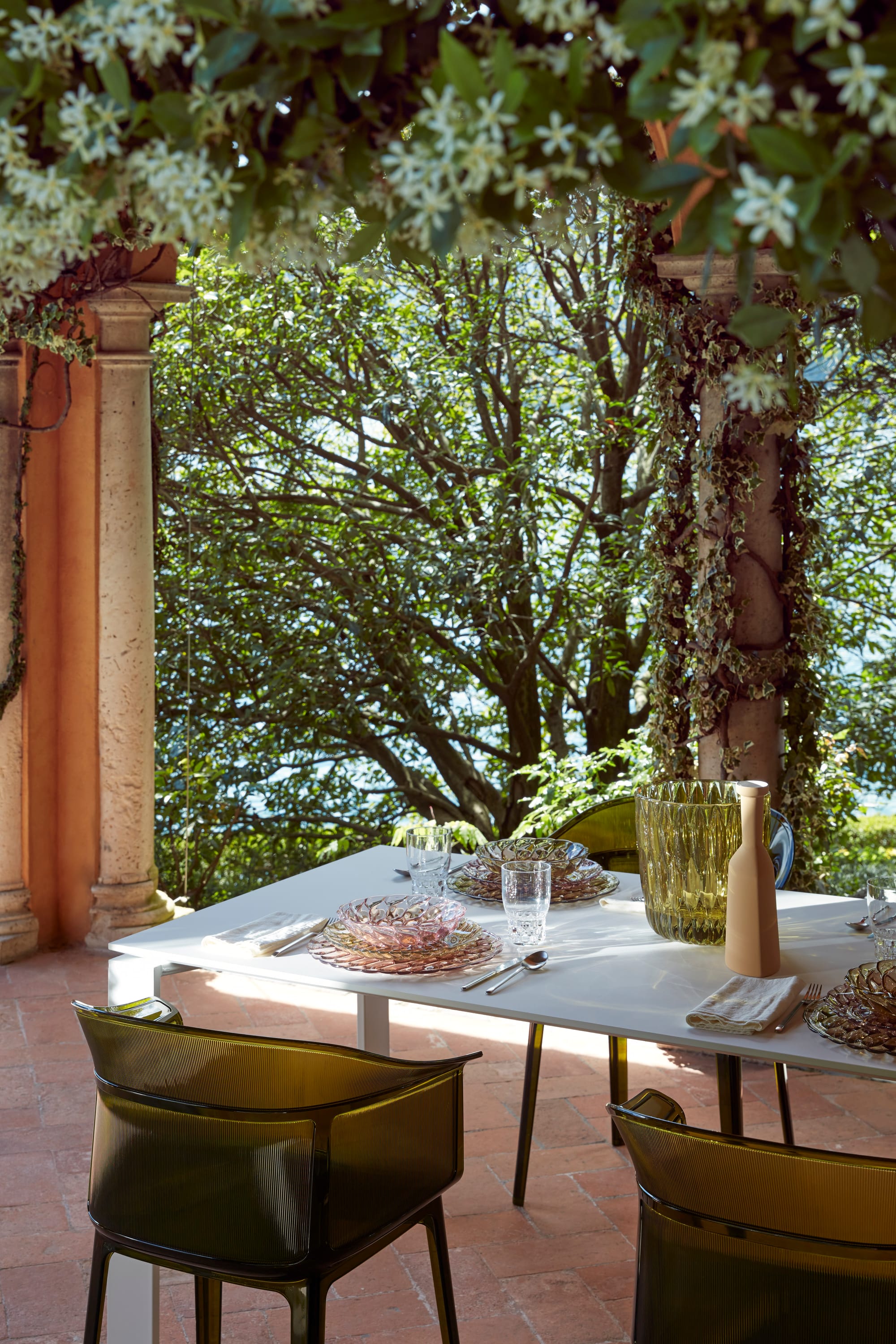 Outdoor Collection Papyrus Chair by Kartell Perth. Dining setting with earth green polyurethane chairs in vegetated loggia with view to Mediterranean landscape. 