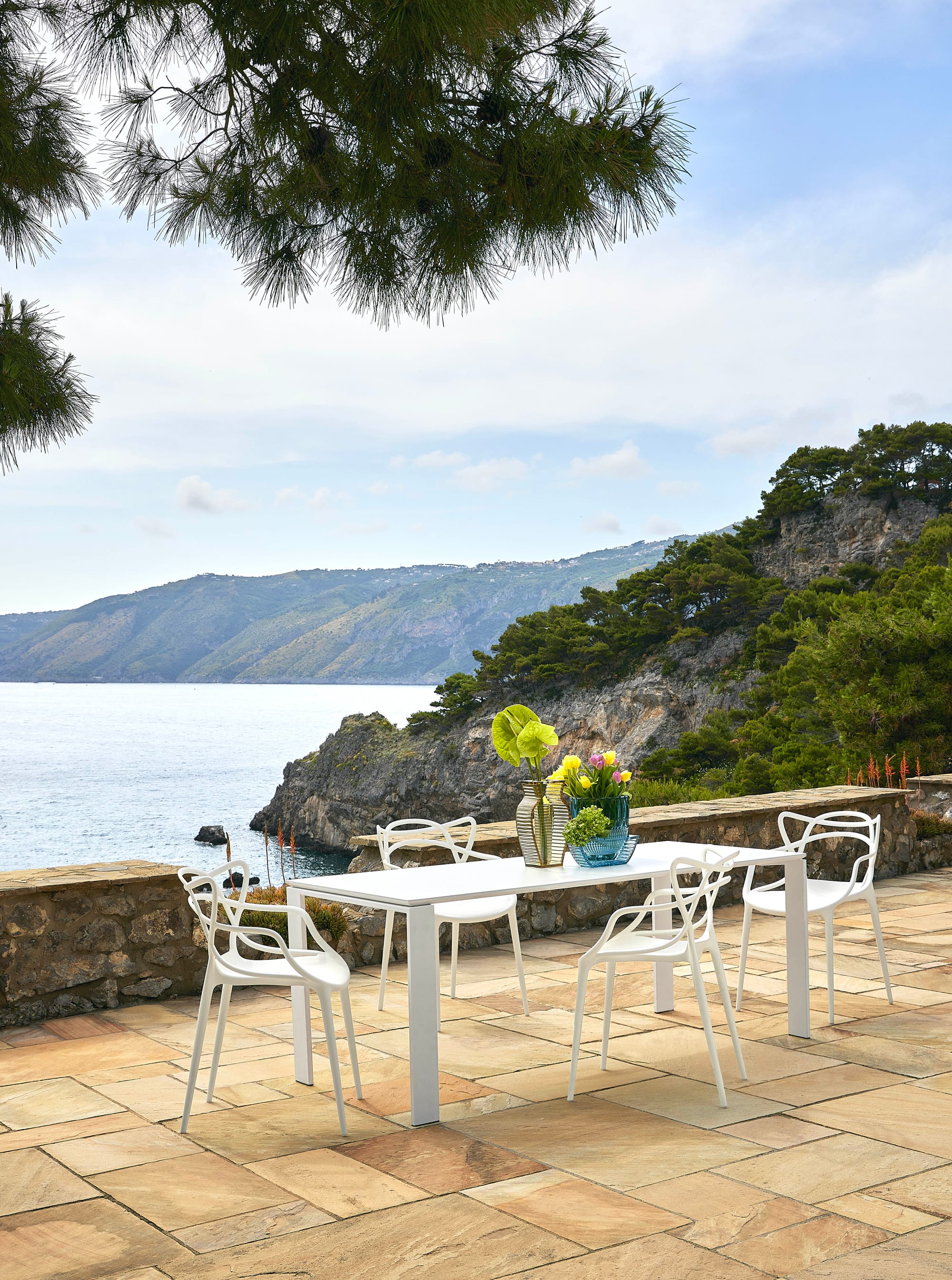 Outdoor Collection Master's Chair and Four Outdoor Table by KartellPerth. Outdoor dining set featuring modern white polyurethane chairs and white dining table in Mediterranean atmosphere.