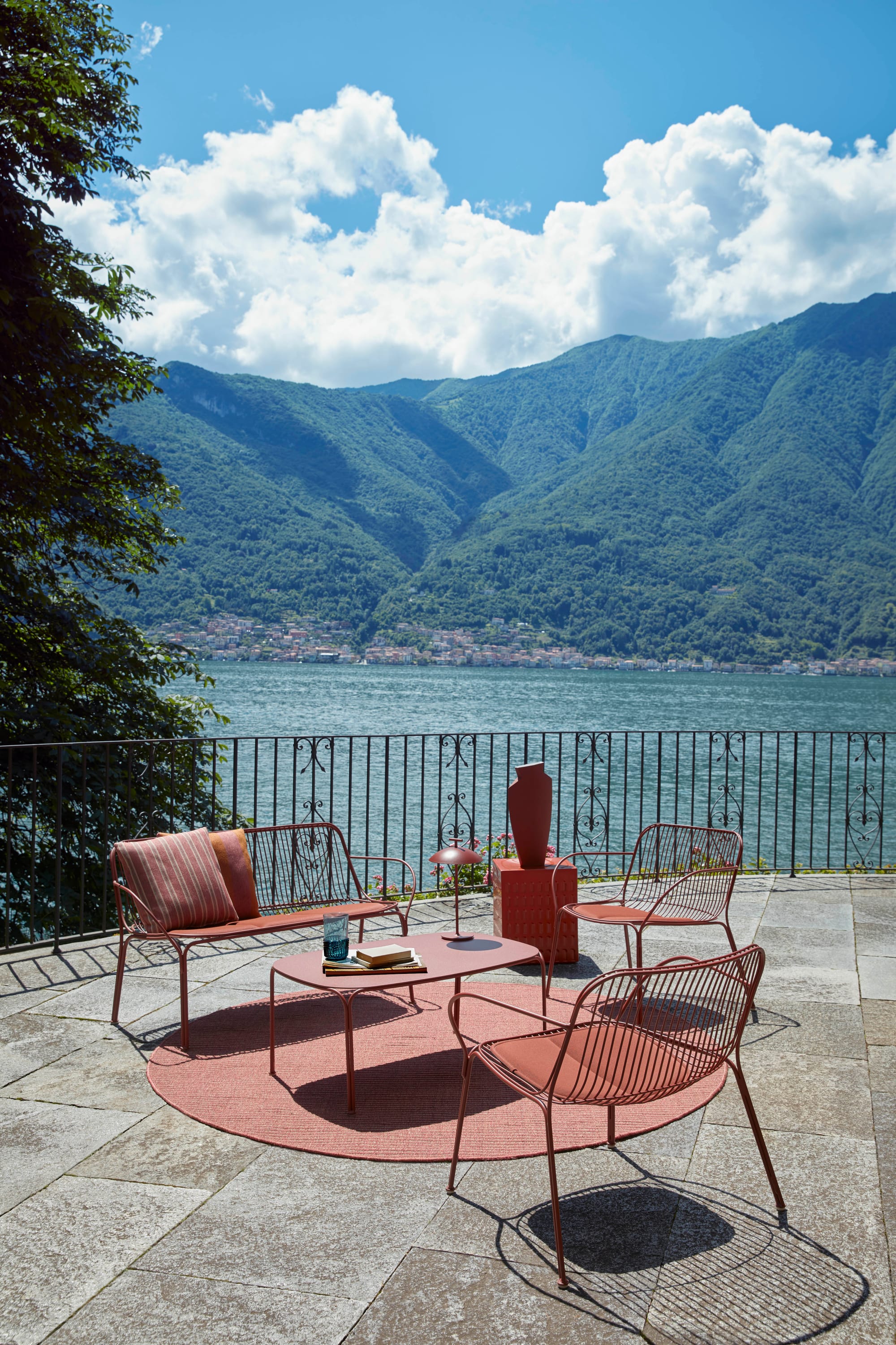 Outdoor Collection Hiray by KartellPerth. Brick coloured metal frame chairs and coffee table on Mediterranean Balcony with view to lake and nature.