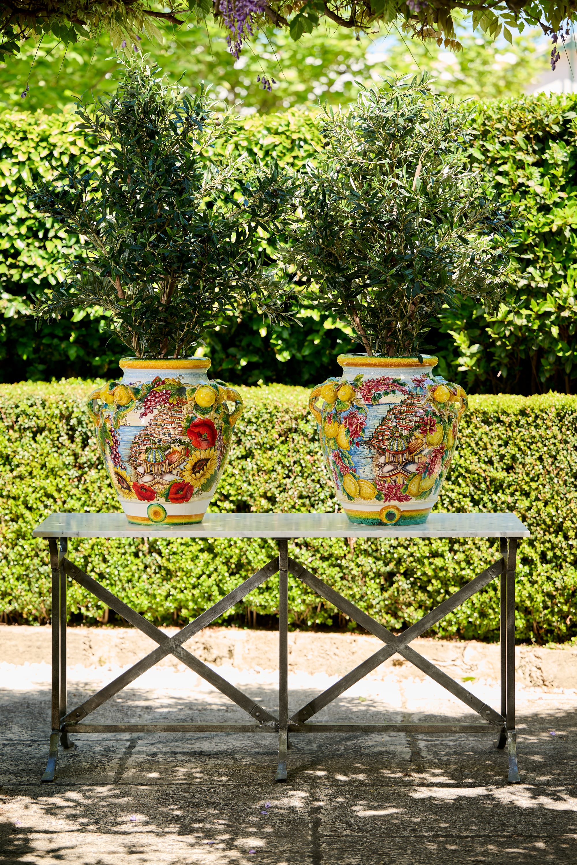 Positano Ceramic Collection Plant Pods and Le Forge Collection Napoli Table by Trilogy. Metal squared outdoor table and big hand painted plant pots in Mediterranean style. 