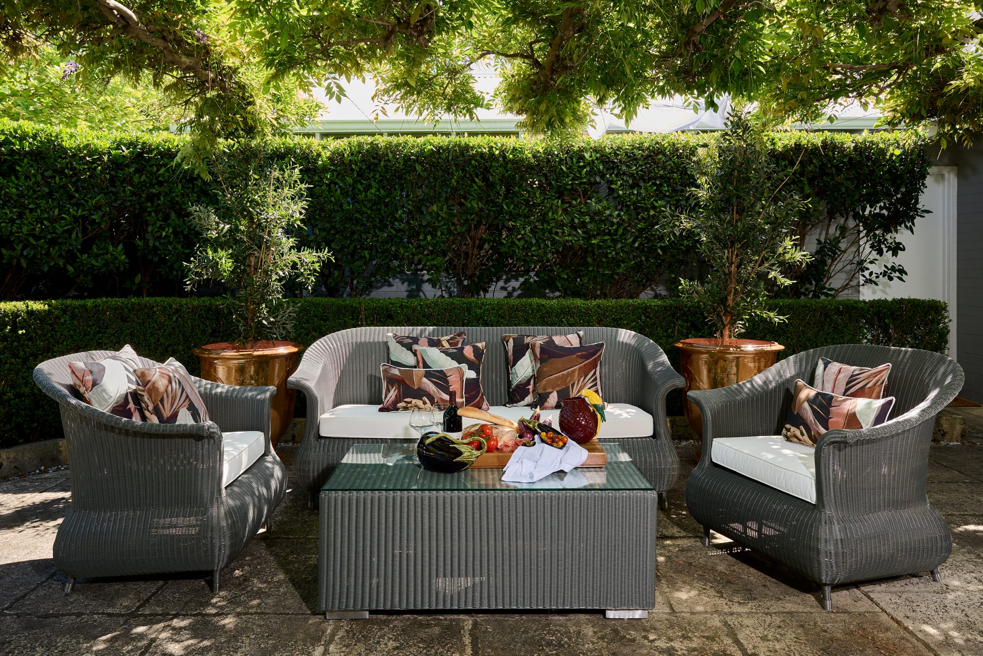 Syntetic Loom Lounge Set by Trilogy.  Modern plaited outdoor 2 seater sofa, lounge chairs and coffee table on terrace.