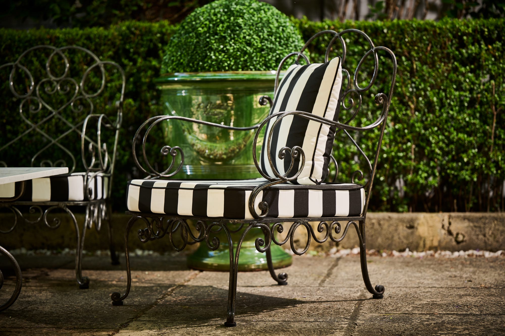 Le Forge Collection Chantilly Restort Chair and Authentic Aduze Collection Plant Pot by Trilogy. Le Forge Collection St Tropez Sun Lounger and Authentic Aduze Collection Plant Pots by Trilogy. Art Nouveau chair and handmade green glazed clay plant pot on terrace.