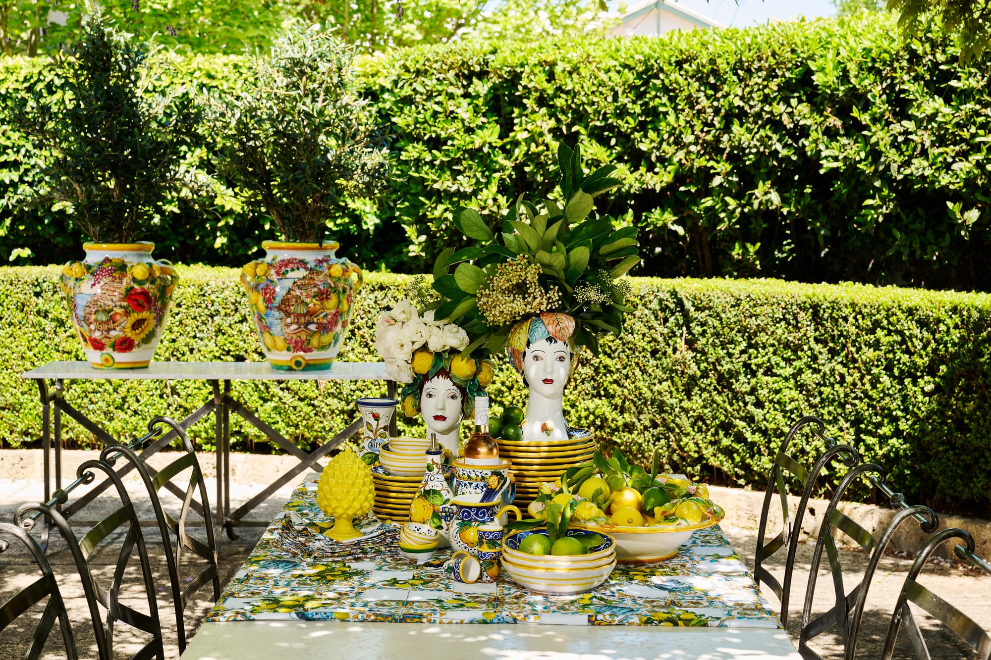 Positano Ceramic Collection Set and Le Forge Collection Napoli Dining Set by Trilogy. Colorful  hand painted ceramic dining set on table in summer outdoor atmosphere.