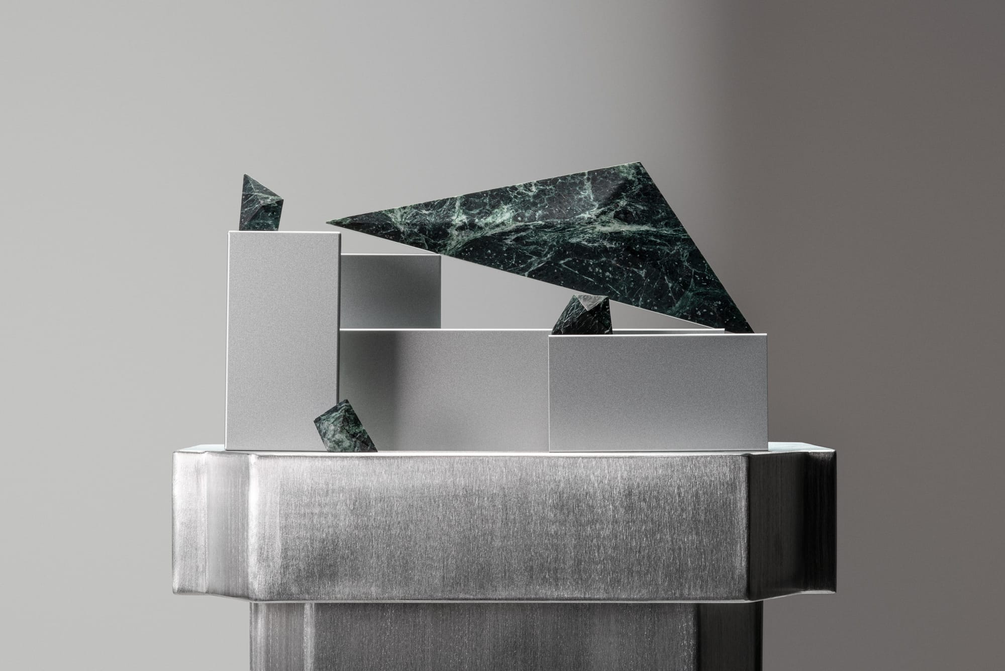 PRISM collection by Lo & Co. Displayed dark green marble joinery collection featuring big, triangular handles and edgy shaped knobs.