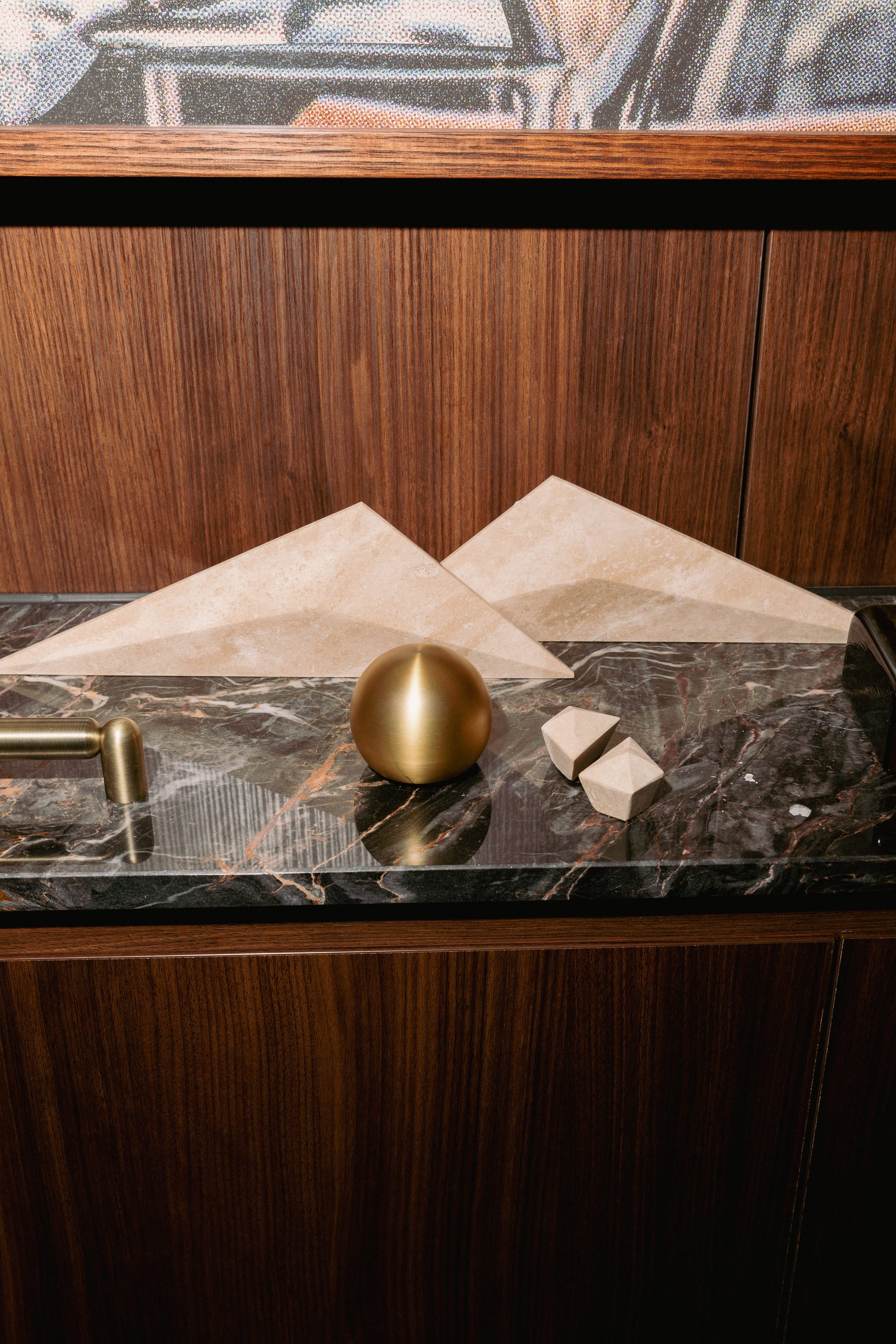 PRISM collection by Lo & Co. Triangular beige marble and round brass joinery on wooden console featuring black marble work top