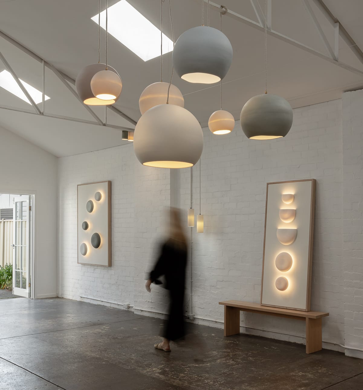 An interior shot of the Studio Enti showroom showing a collection of lights hanging and on the walls