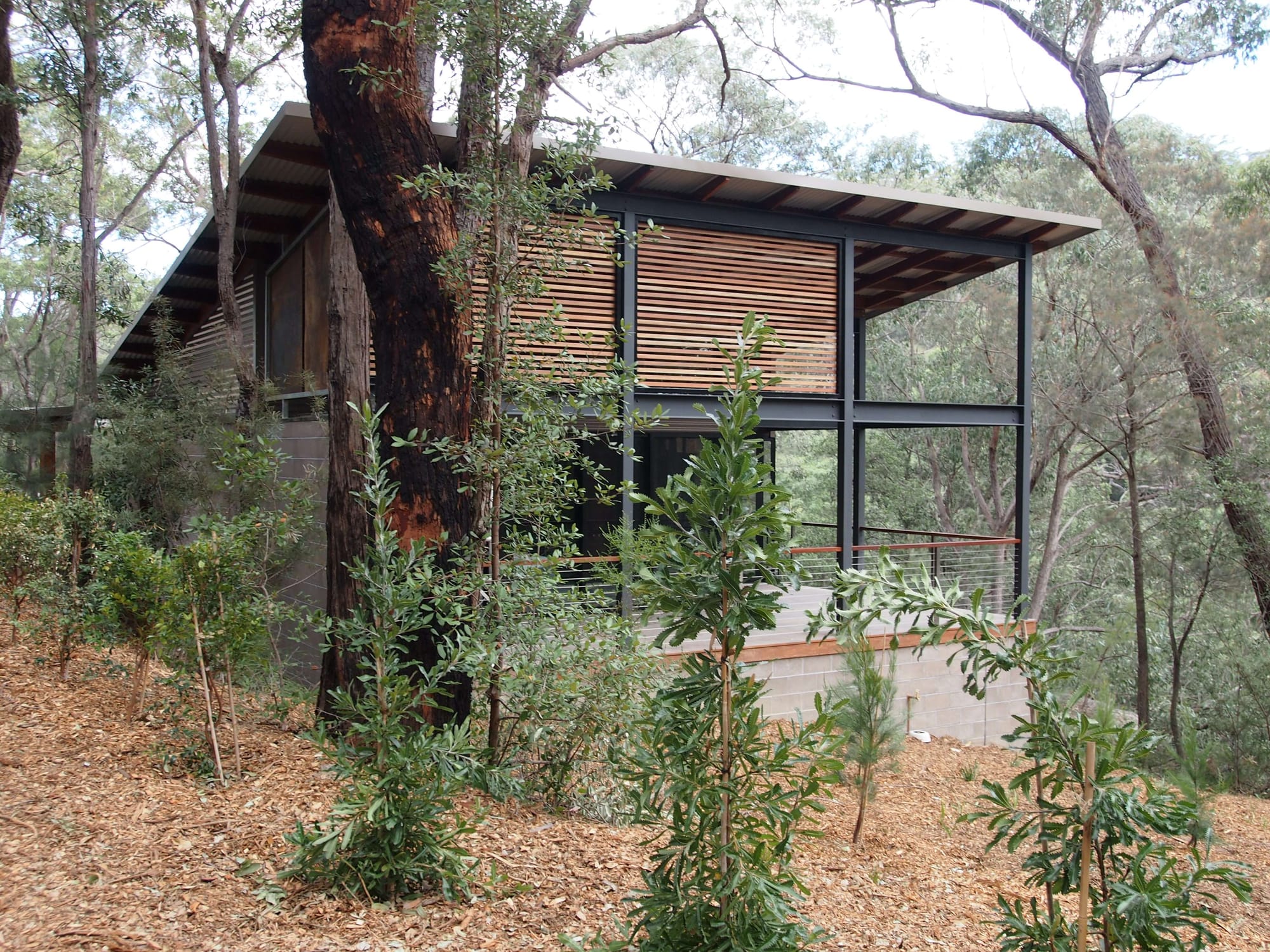 Spicers Sangoma by Barbara Tarnawski Architects. Exterior of residential home with patio, timber awnings and surrounding bushland. 