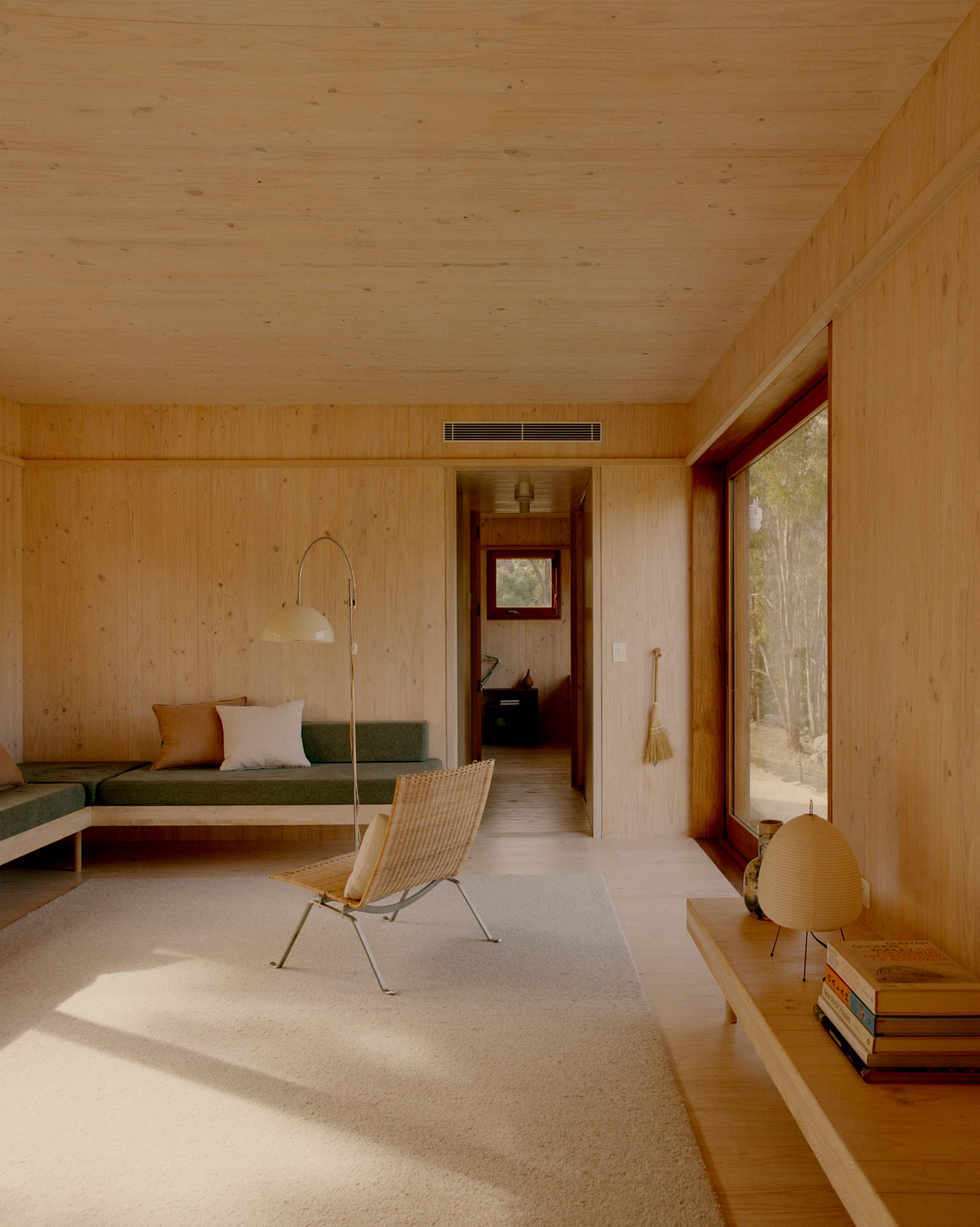 Practice Ground. Photography by Saskia Wilson. Living space with light carpet rug, integrated timber and sage linen bench seating, timber joinery and walls. 