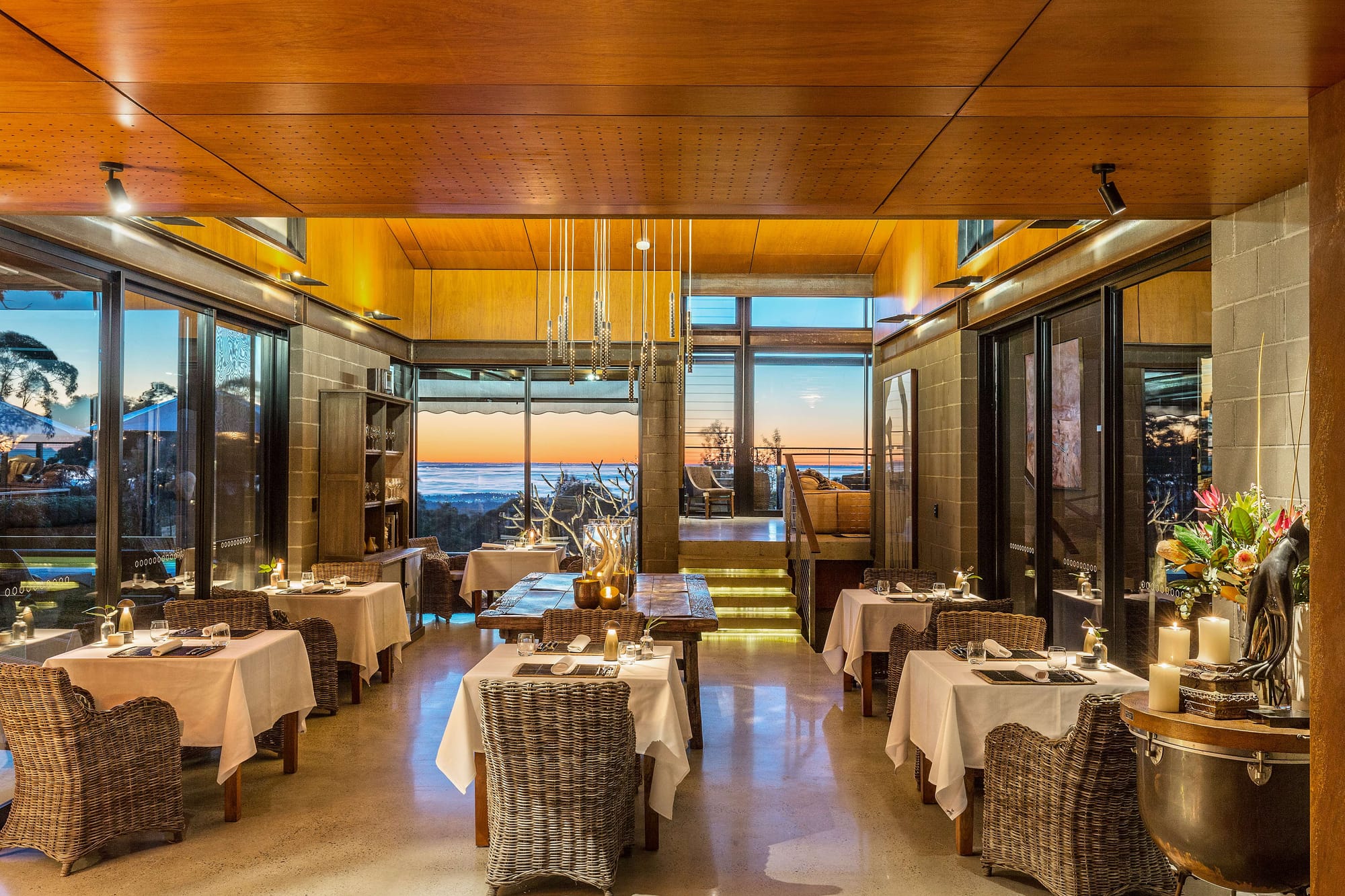 Spicers Sangoma by Barbara Tarnawski Architects. Hospitality dining space with multiple small tables, timber roof and warm lighting. 